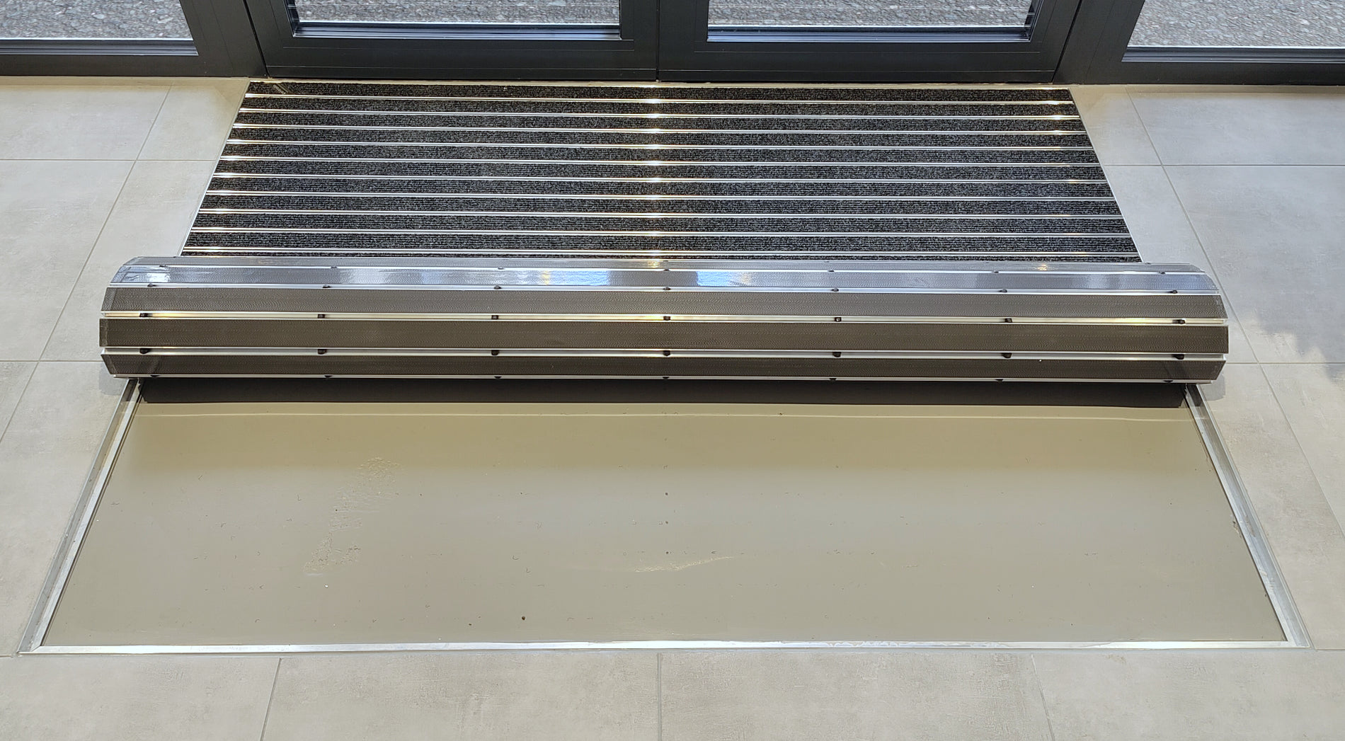 aufgerollte Eingangsmatte in Bodenvertiefung