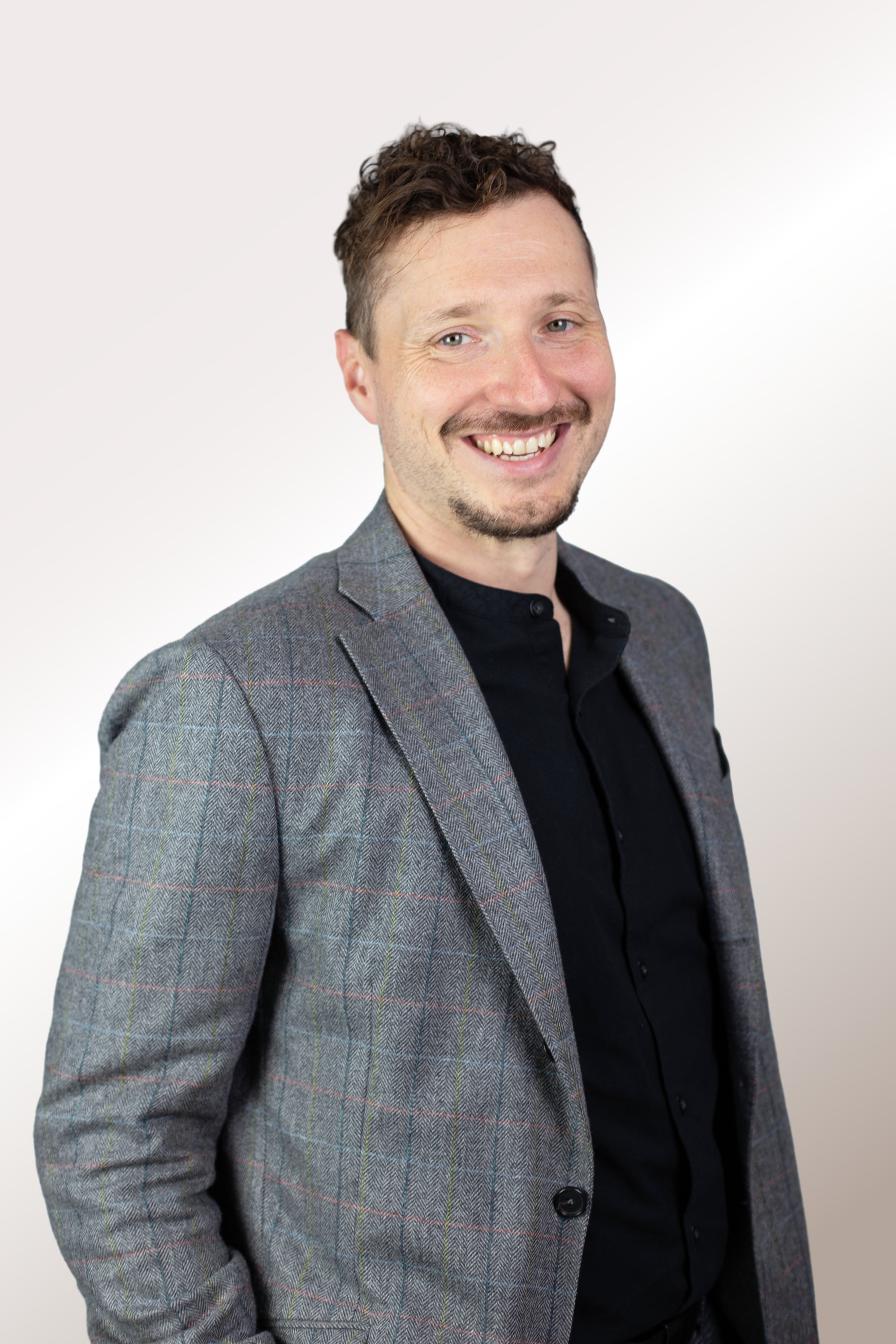 Bild eines sympatischen Mitarbeiters der in die Kamera lächelt