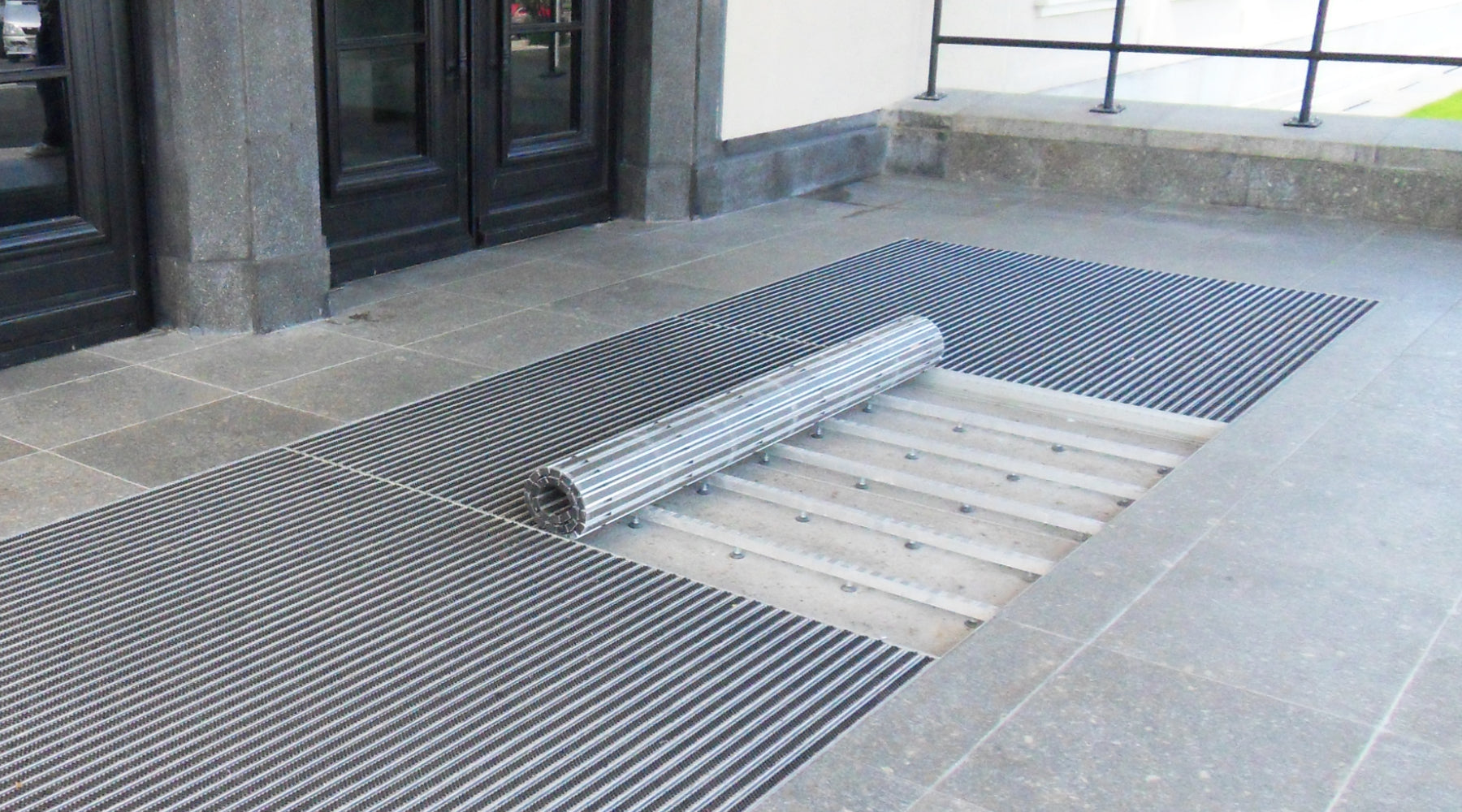 Eingangsmatte aufgreollt in Wanne vor Eingang