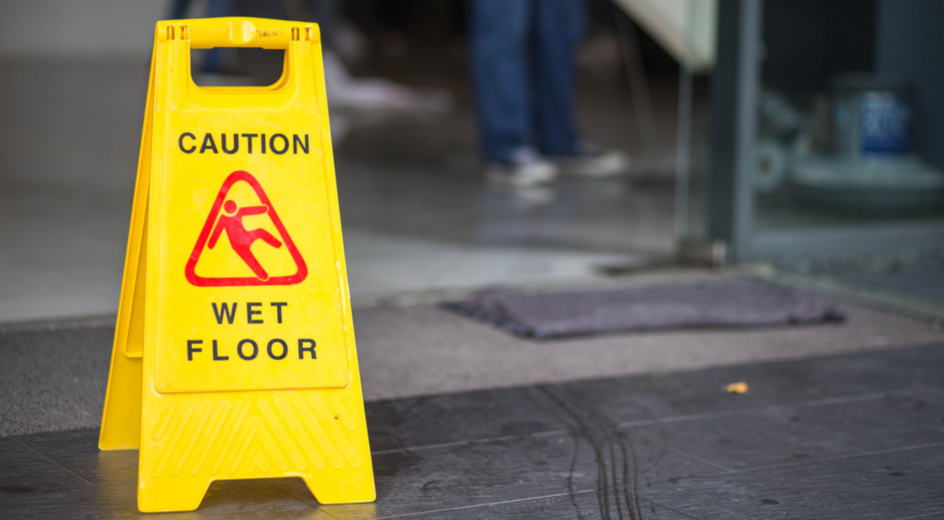 Nasser Eingangsbereich mit Rutschgefahr Hinweis