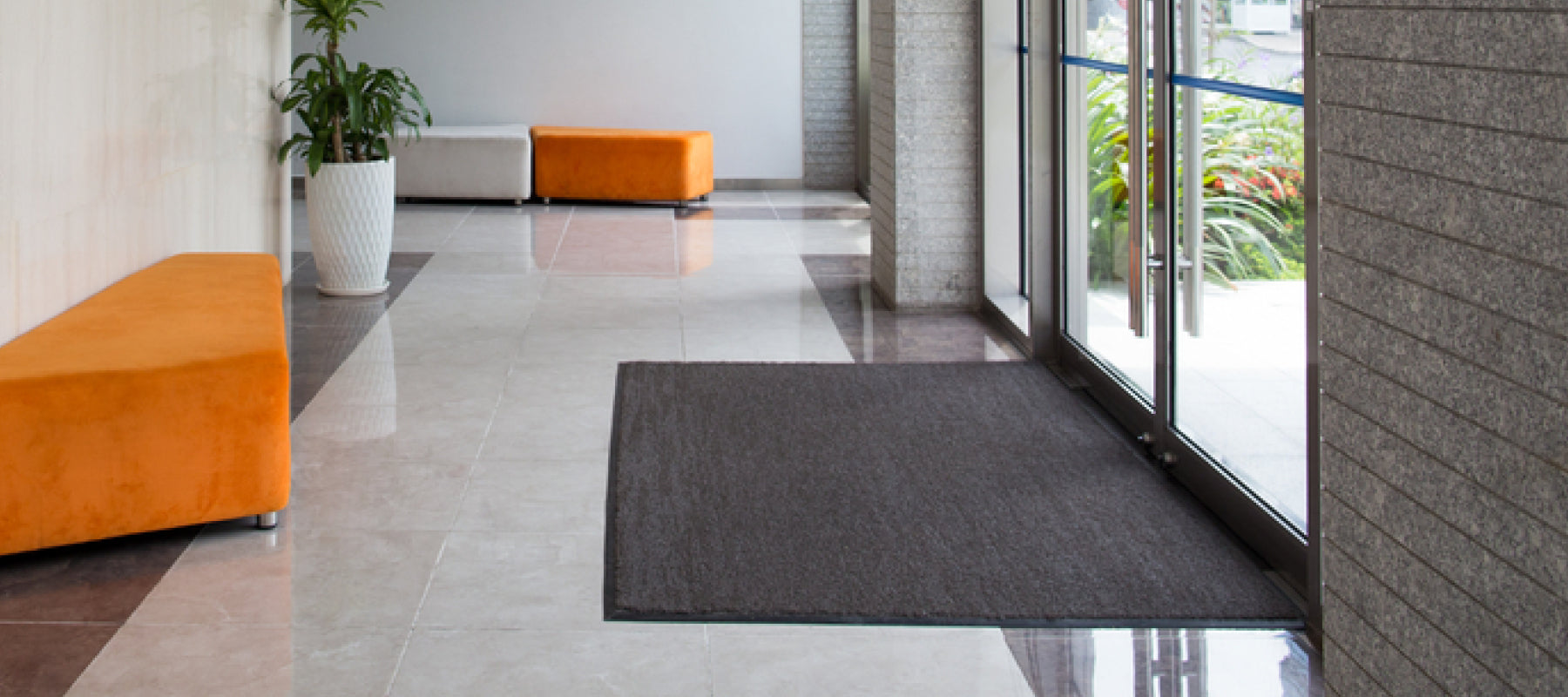 Sauberlaufmatte in einem hellen Eingangsbereich mit Sitzgelgenheiten