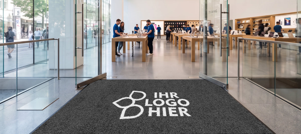 Eingangsmatte vor einer Glastür, halb Aluprofilmatte und halb Sauberlaufmatte, Text am unteren Bildrand: 115 x 180 cm.