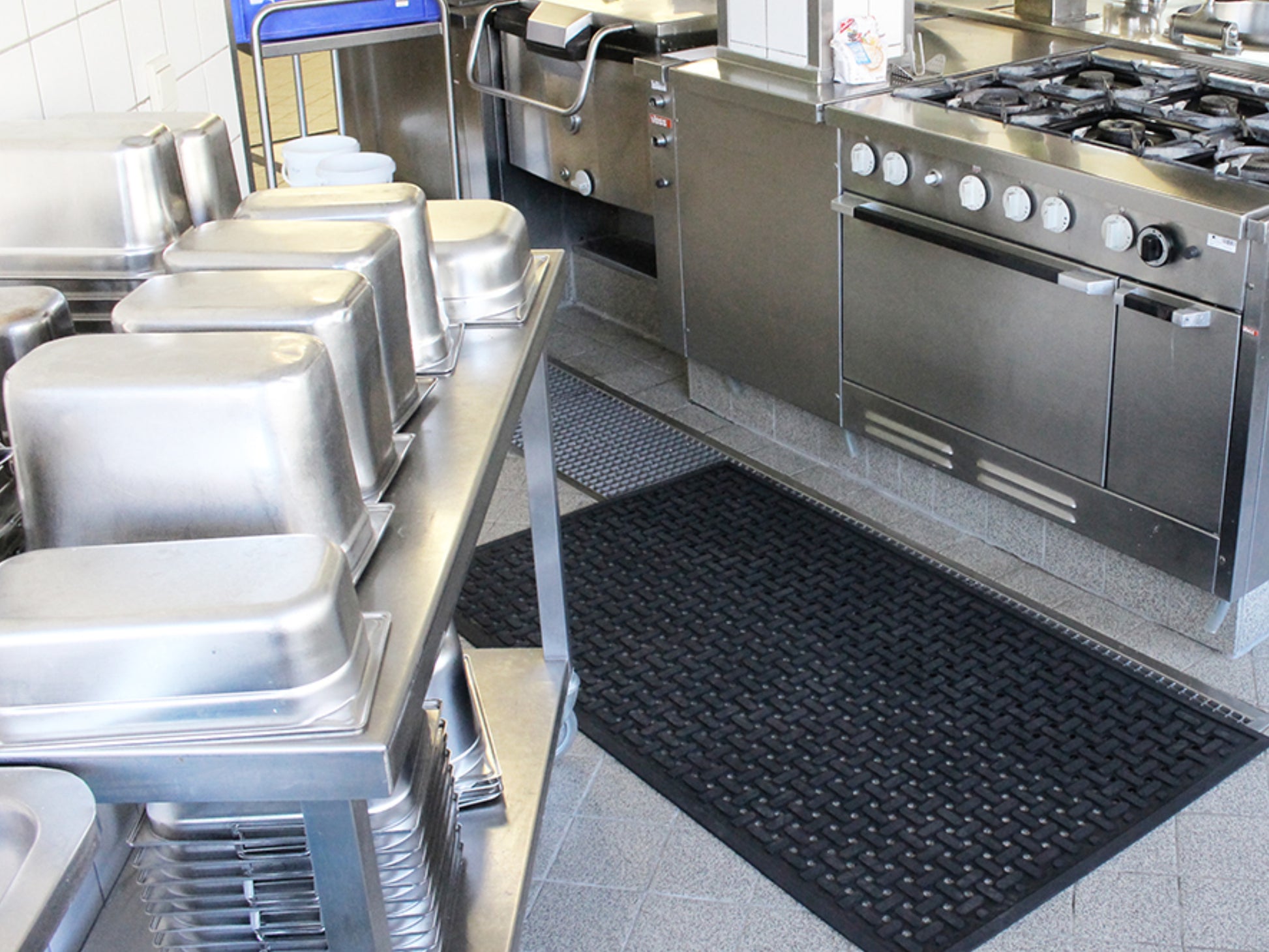 Arbeitsplatzmatte aus Gummi mit Drainagelöchern liegt auf dem Boden einer Großküche