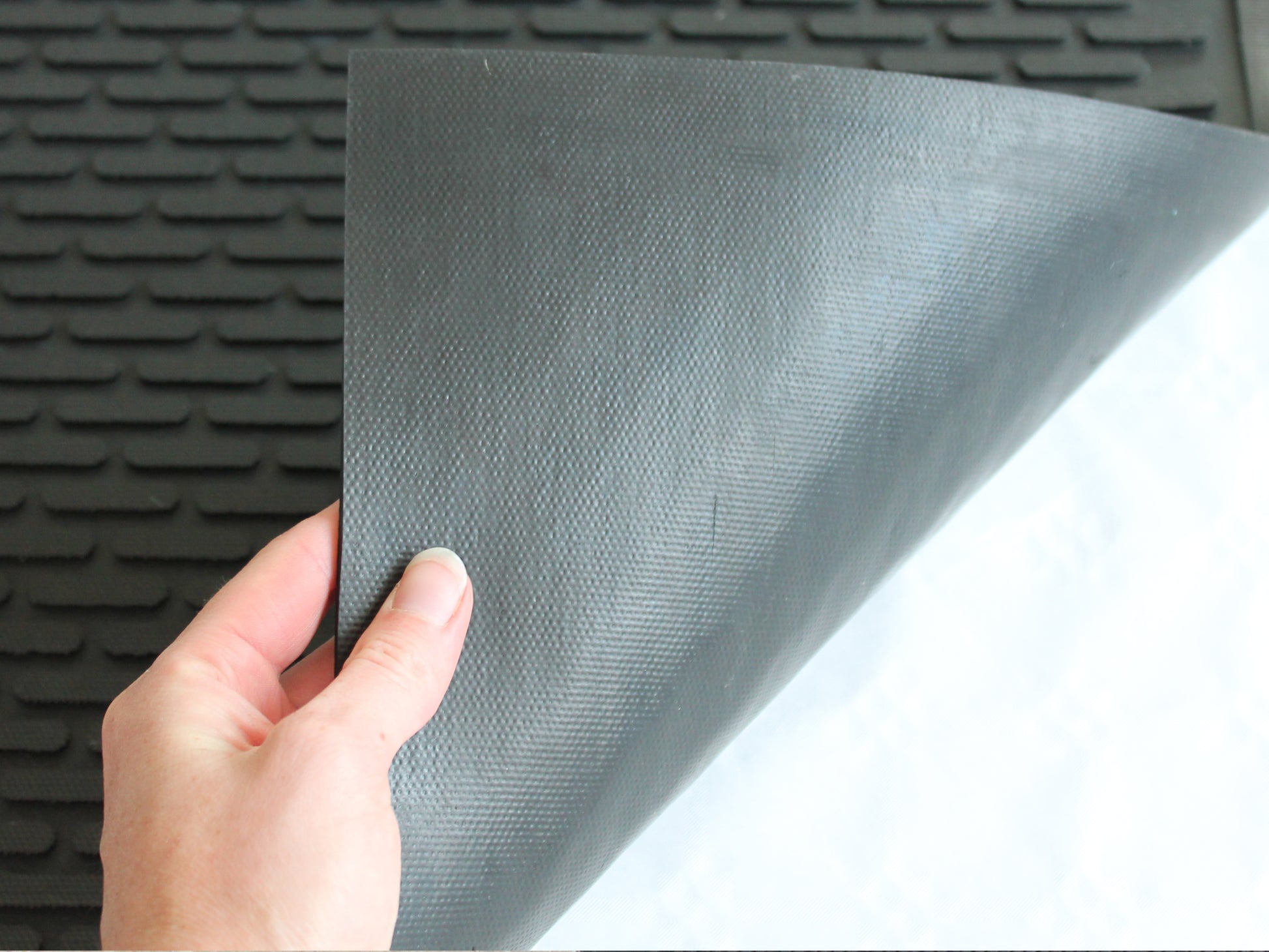 Umgeklappte Ecke der Arbeitsplatzmatte Pro Work mit Gummioberfläche