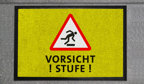 Bedruckte Fußmatte als Warhinweis mit dem Aufdruck vorsicht Stufe