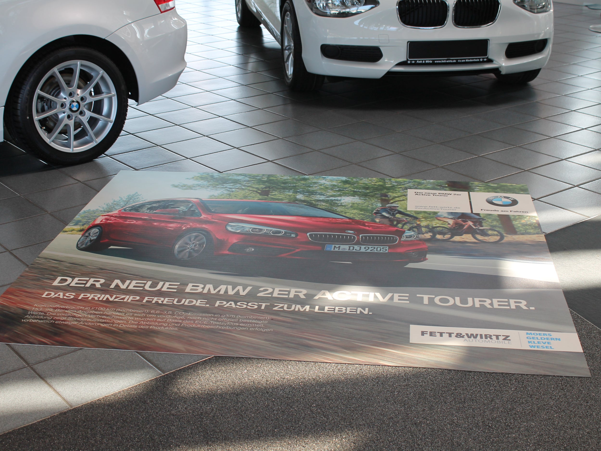 Fotorealistisch bedruckter Bodenbelag mit BMW Werbung liegt in einem Autohaus