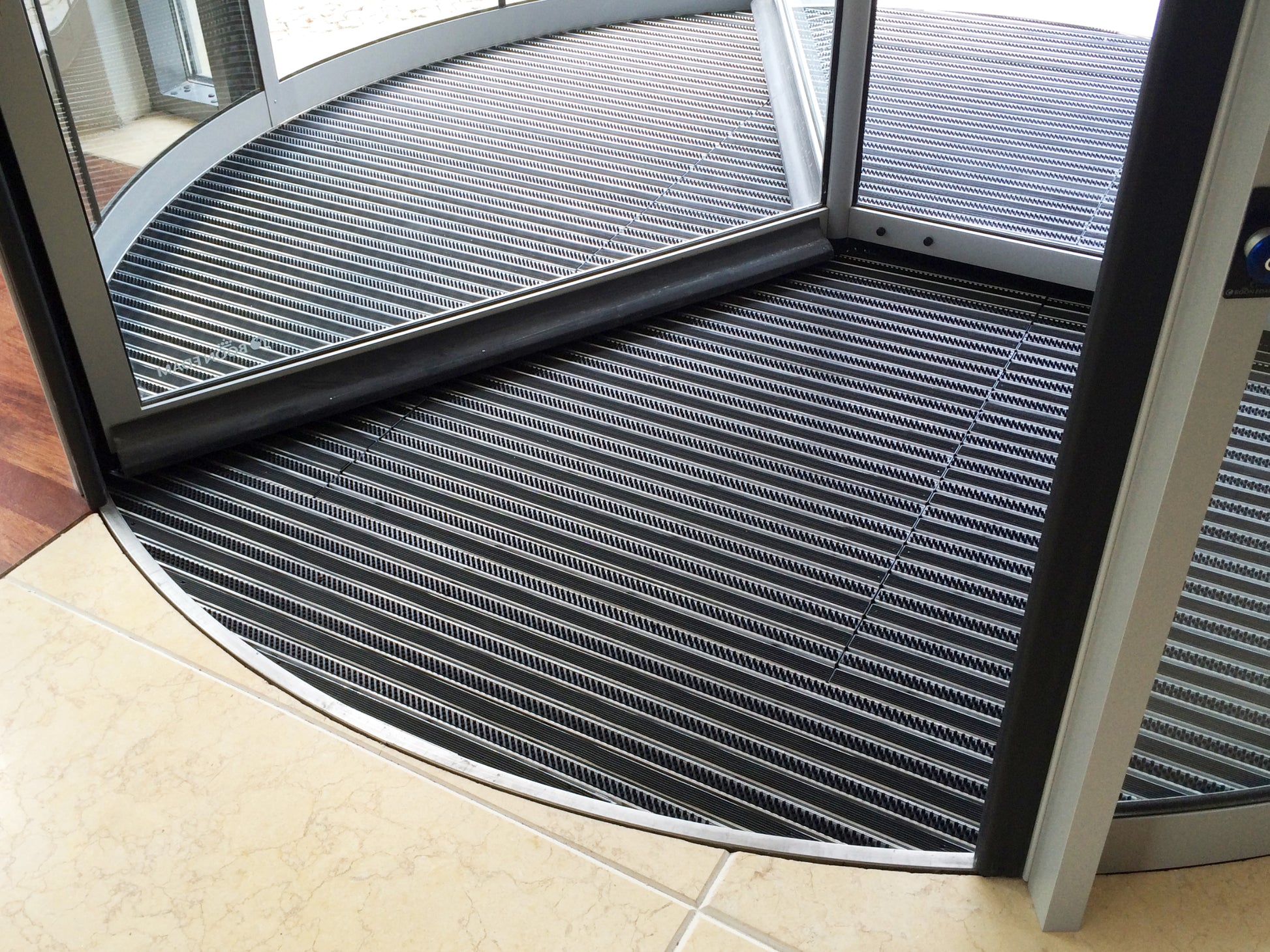 Abdeckschiene und eingelassene Fußmatte in Drehtür