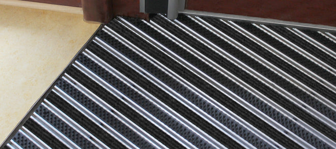 Aluminium Fußmatte mit Rips und Bürsten im Boden eingelassen
