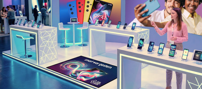 Messestand mit Smartphones und einer bedruckten Fußmatte mit Werbung