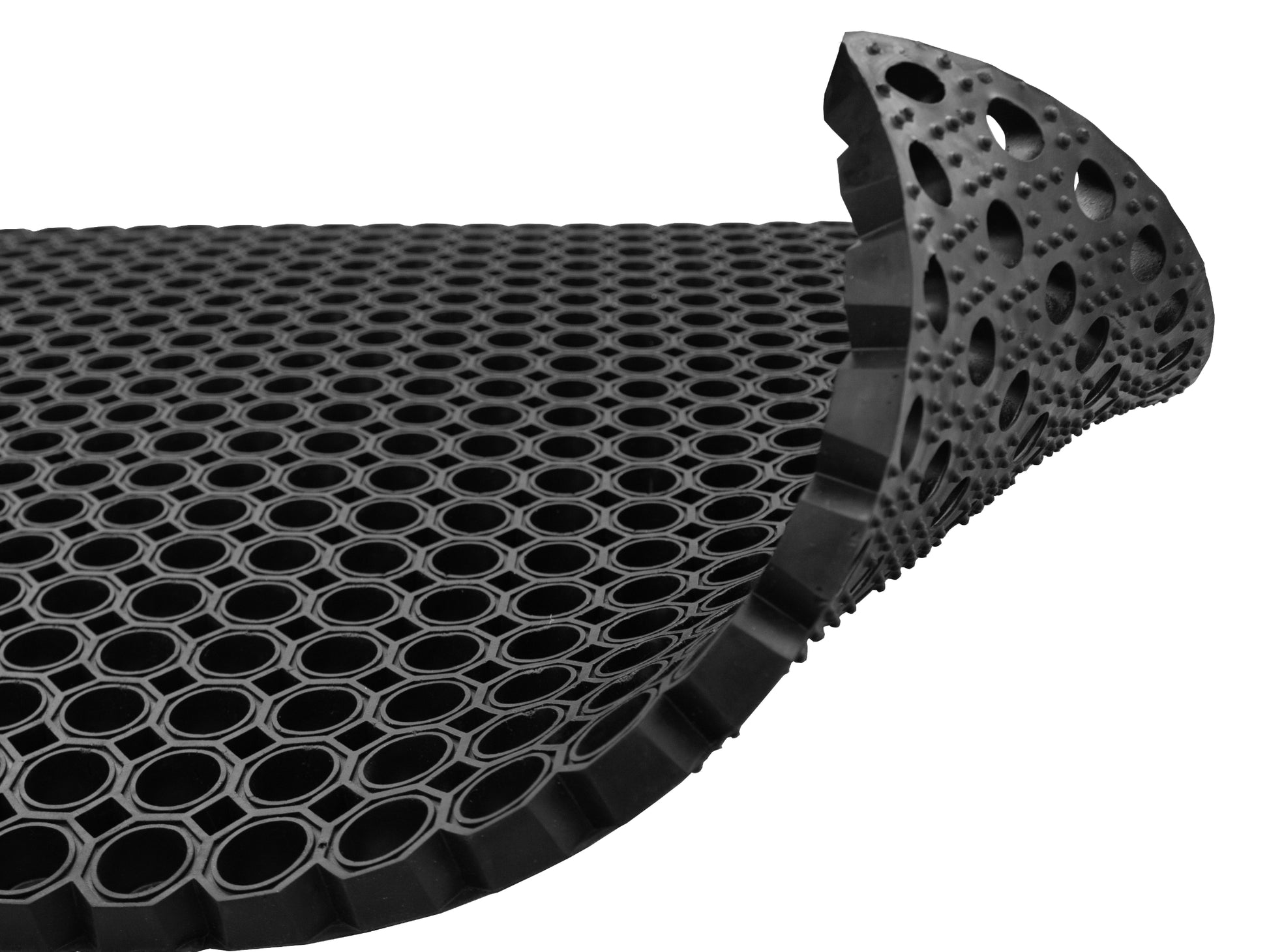 Hochgeklappte Ecke einer Fußmatte aus Gummi mit Drainagelöchern