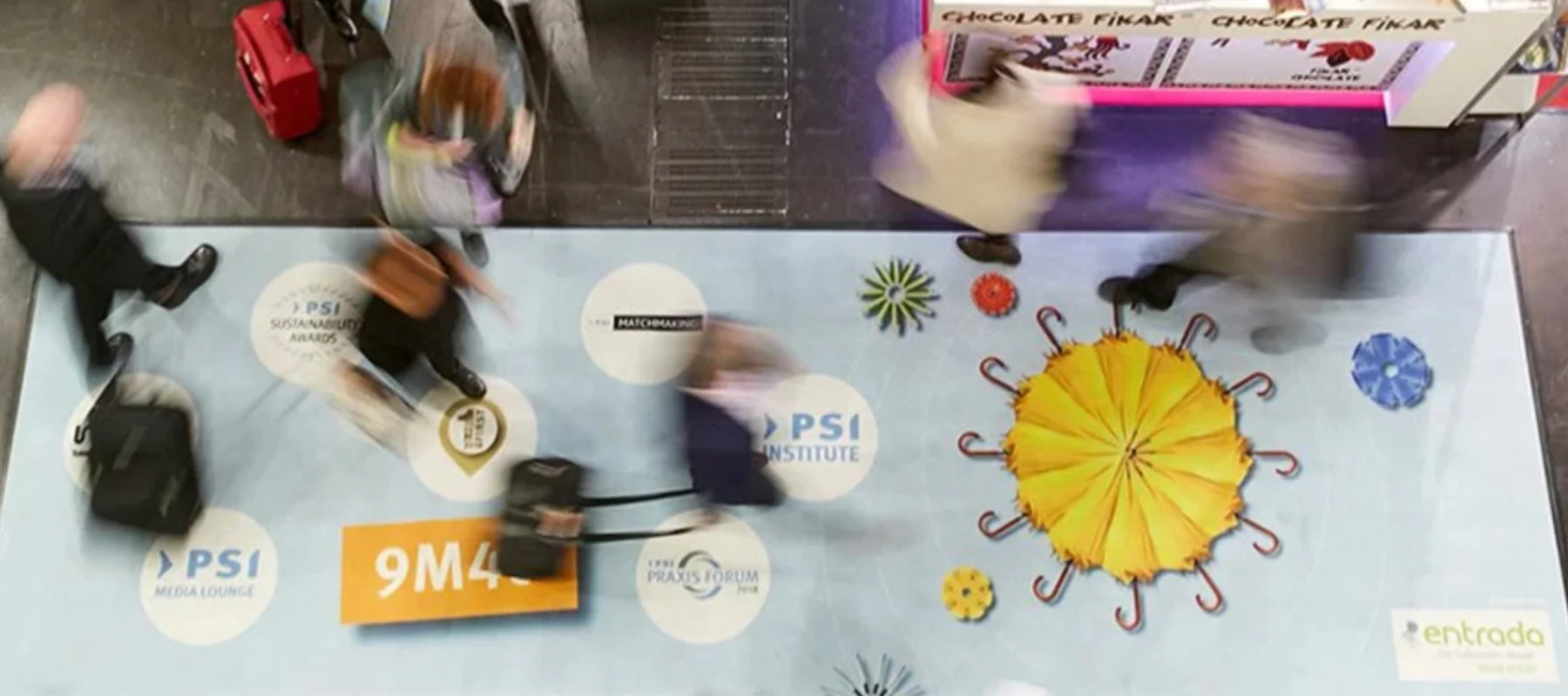 Fußmatte mit Aufdruck auf einer Messe, die von Besuchern überschritten wird