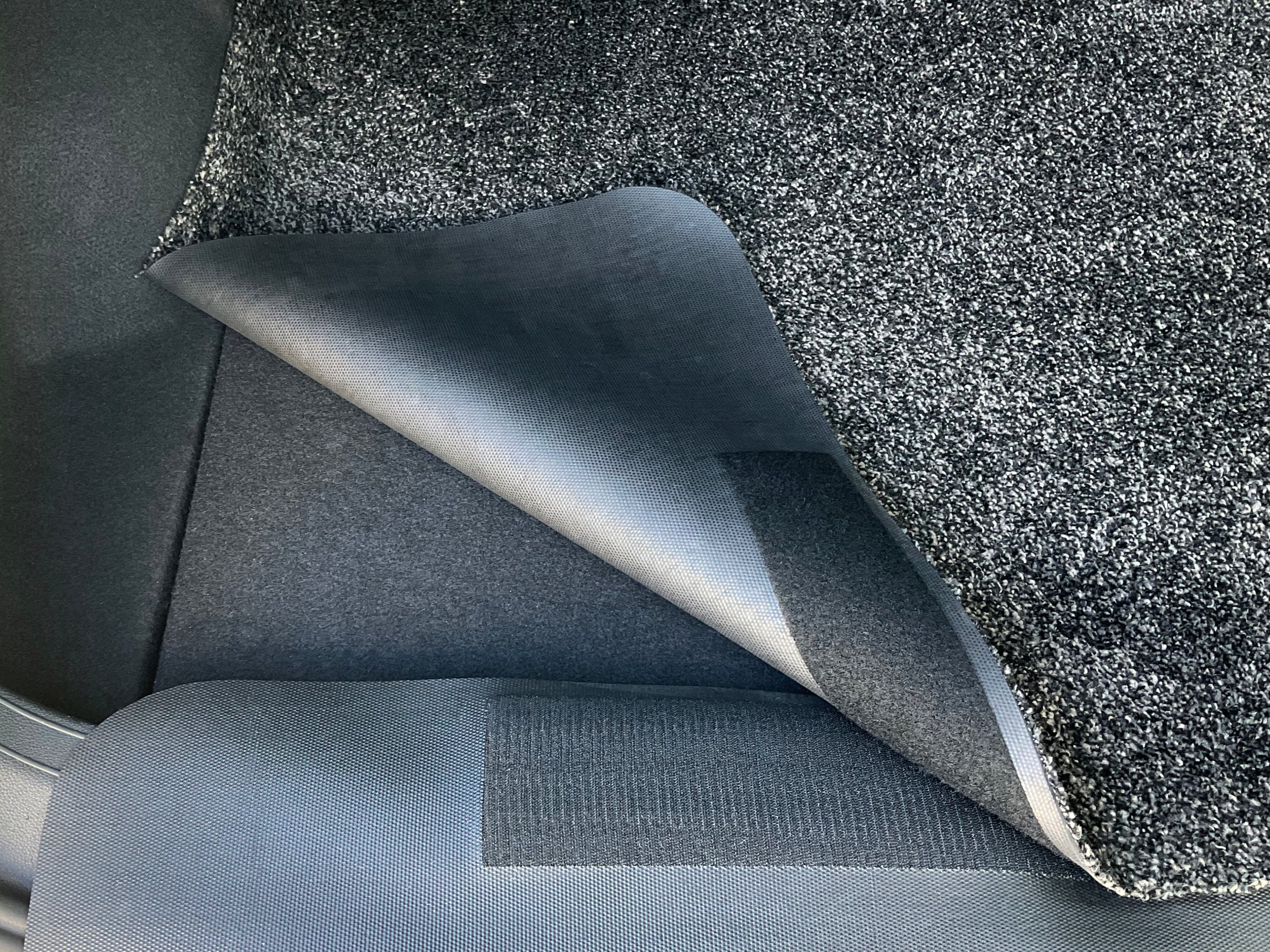 Kofferraummatte und Ladekantenschutz sind mit Klett verbunden und liegen im Auto