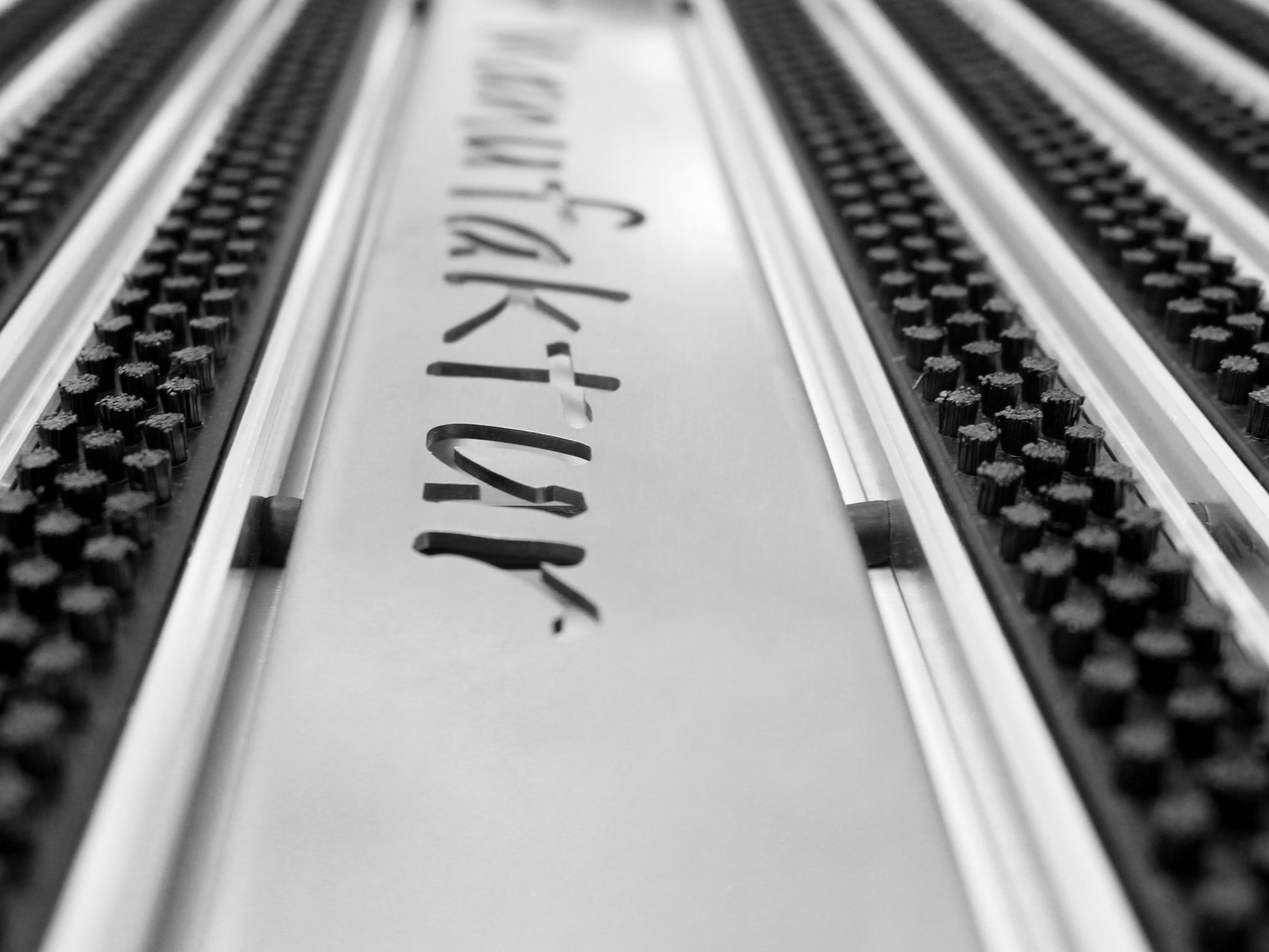 Nahaufnahme einer Aluprofilmatte mit Schriftzug