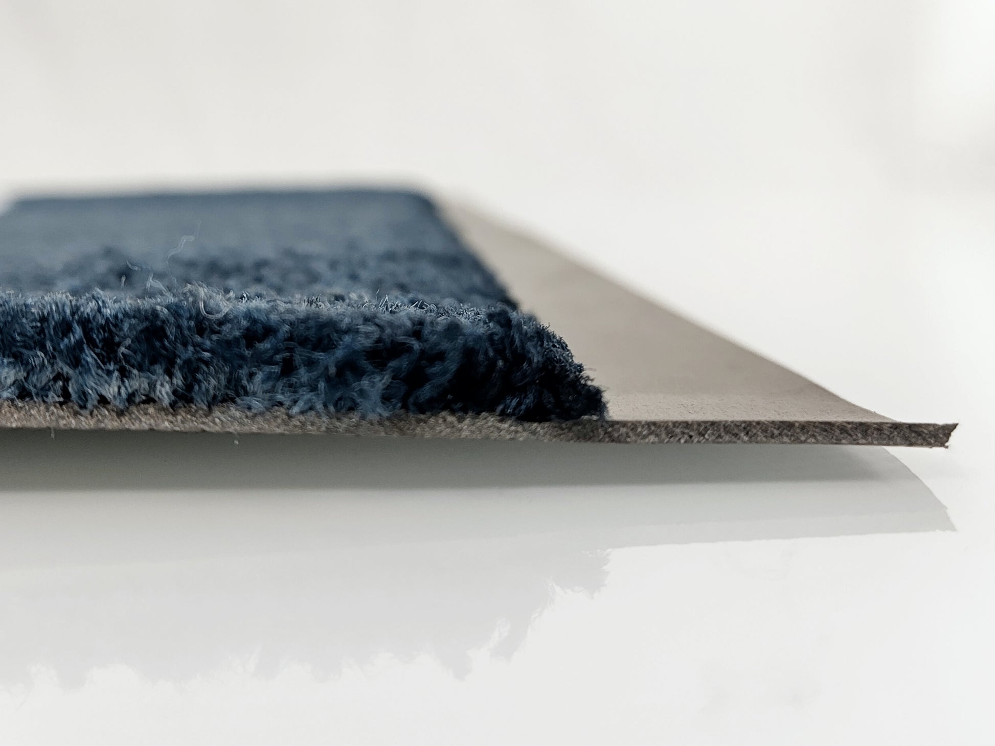 Aus dem Profil: Graue Logomatte mit schwarzen PVC-Rücken und Rand