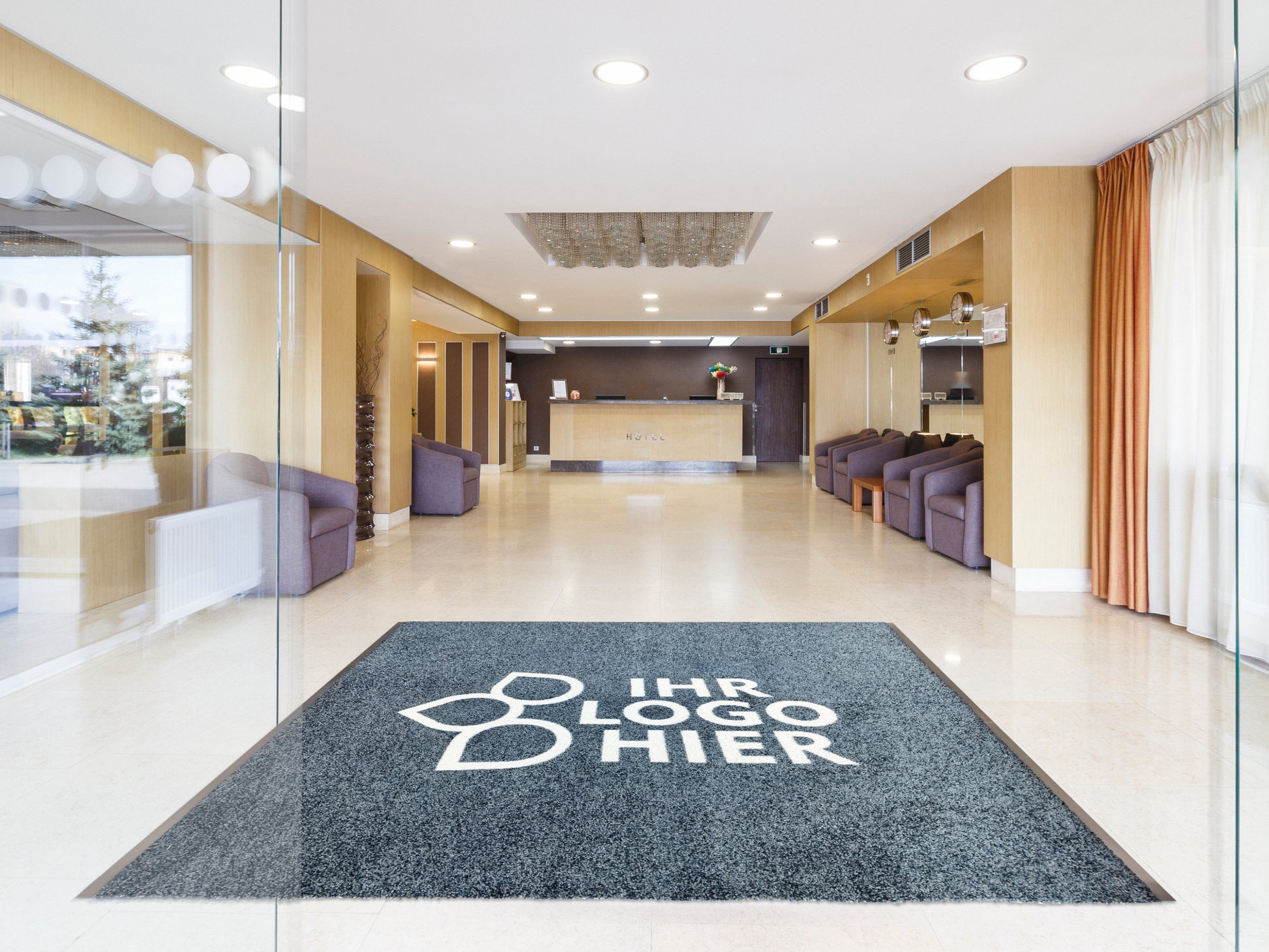 Extra lange Logomatte Grau mit weißer Schrift liegt in Hotellobby am Eingang