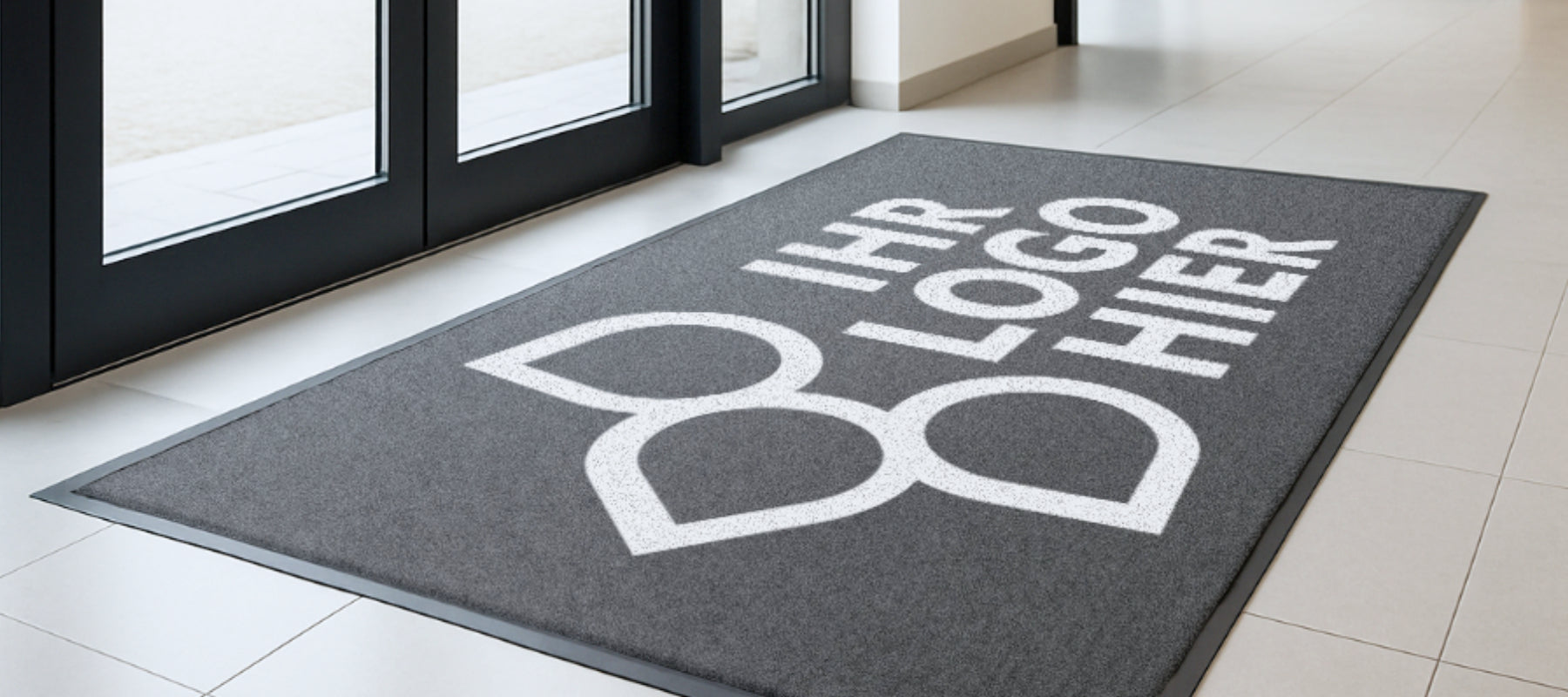 Fußmatte mit Ihr Logo hier Aufdruck und Blütenlogo in einem Eingangsbereich
