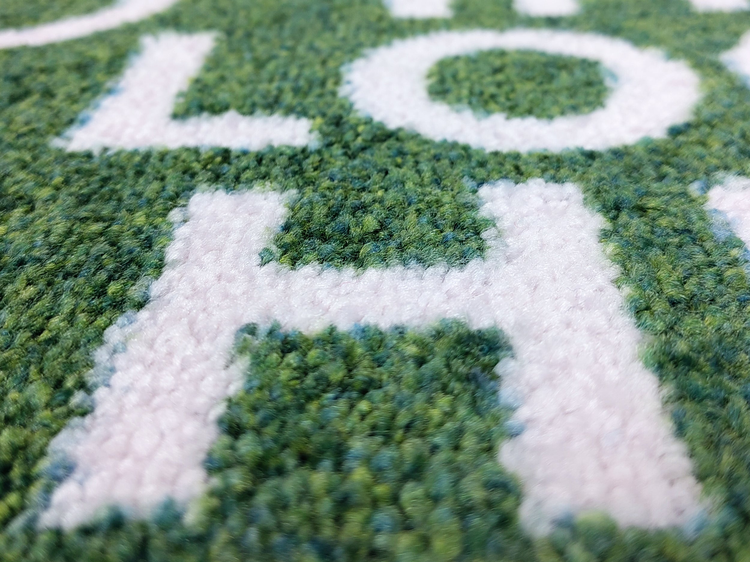 Nahaufnahme des Druckbildes einer nachhaltigen und grünen Logomatte mit weißer Schrift