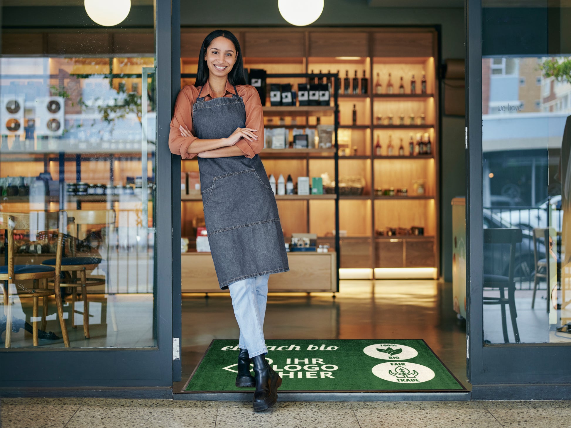 Nachhaltige Logomatte in Bio Supermarkt mit lachender Mitarbeiterin an der Tür