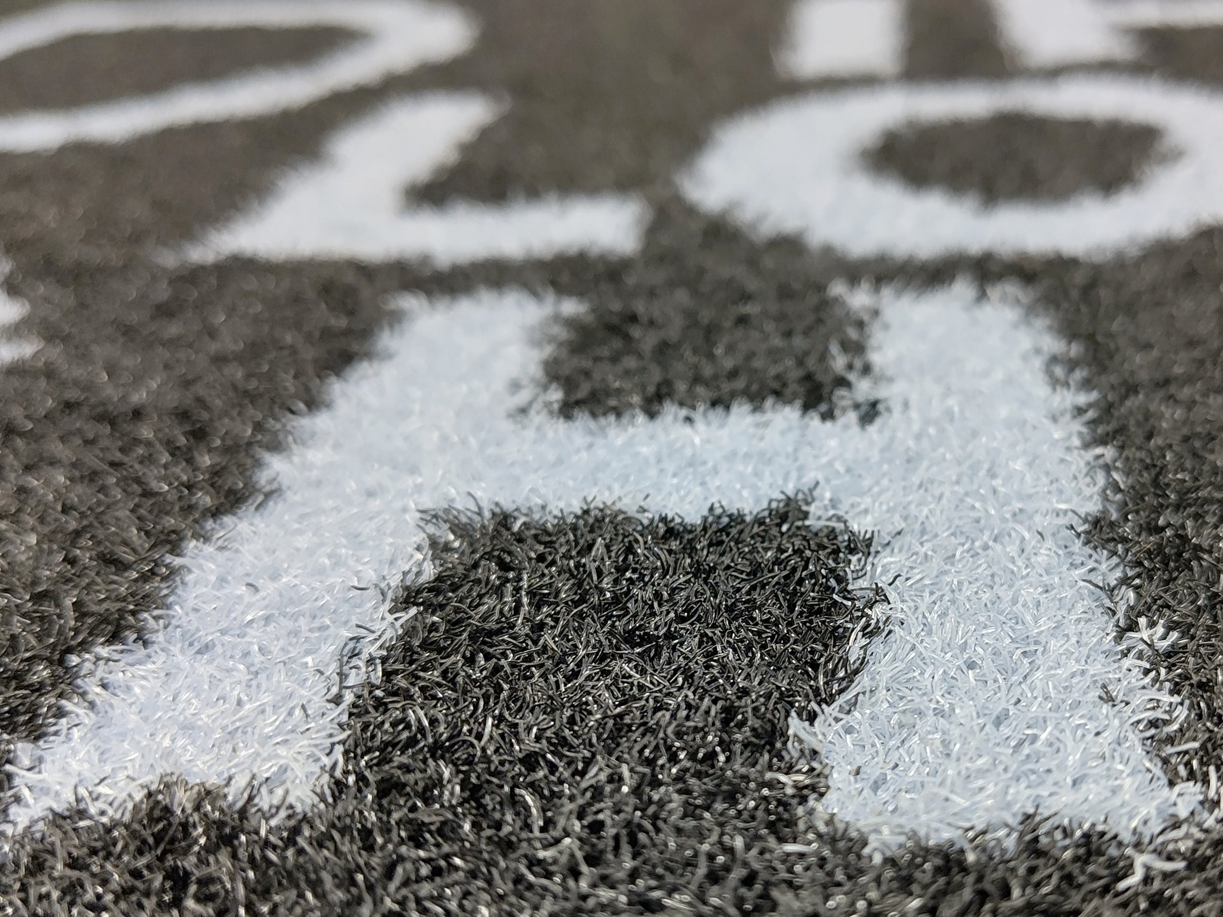 Nahaufnahme des Druckbilds einer dunklen Outdoormatte mit weißer Schrift