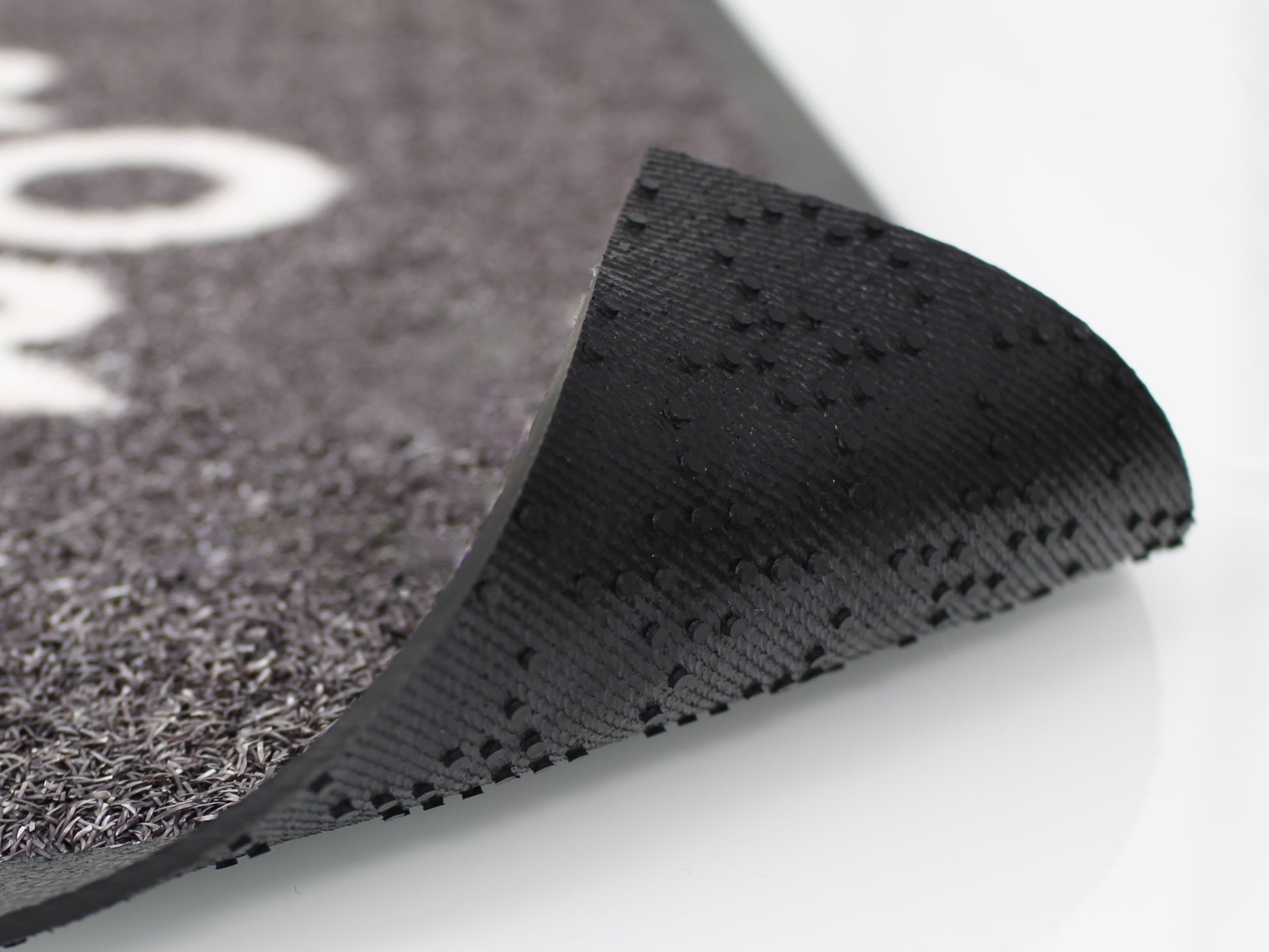 Dieses Bild zeigt eine hochgeklappte Matte, die eben die noppige, gummiartige Rückseite dessen zur schau bringt. 
