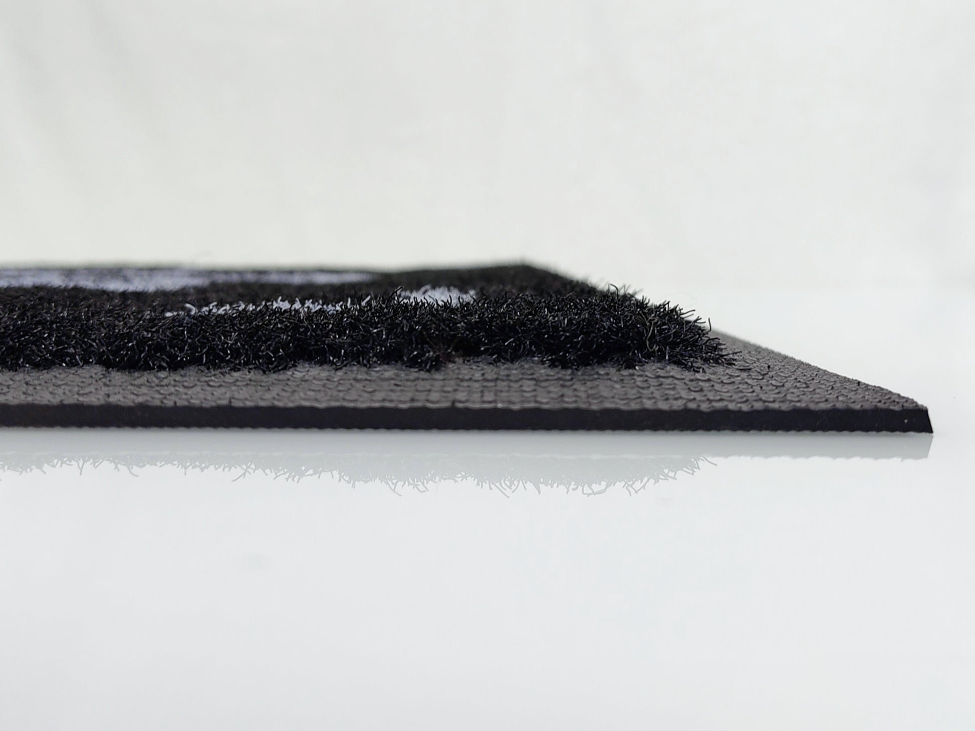 Profilansicht einer schwarzen Outdoor Logomatte rutschfesten Rücken