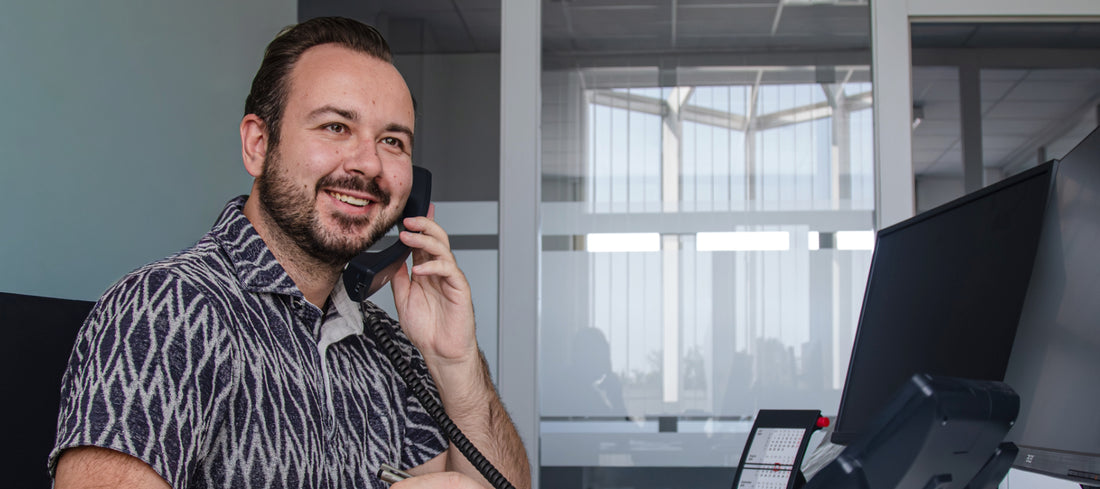 sympatischer Mitarbeiter der mit einem Kunden telefoniert