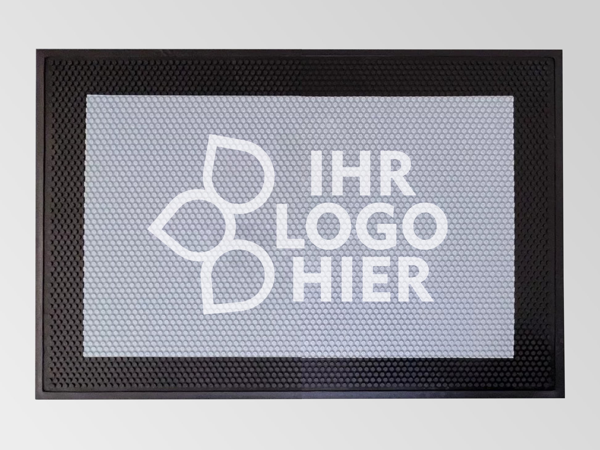 Der Fußabtreter Safe aus Gummi, der auf einem Betonboden liegt, hat eine strukturierte Oberfläche und eine Bedruckung mit dem Logo einer Tischlerei