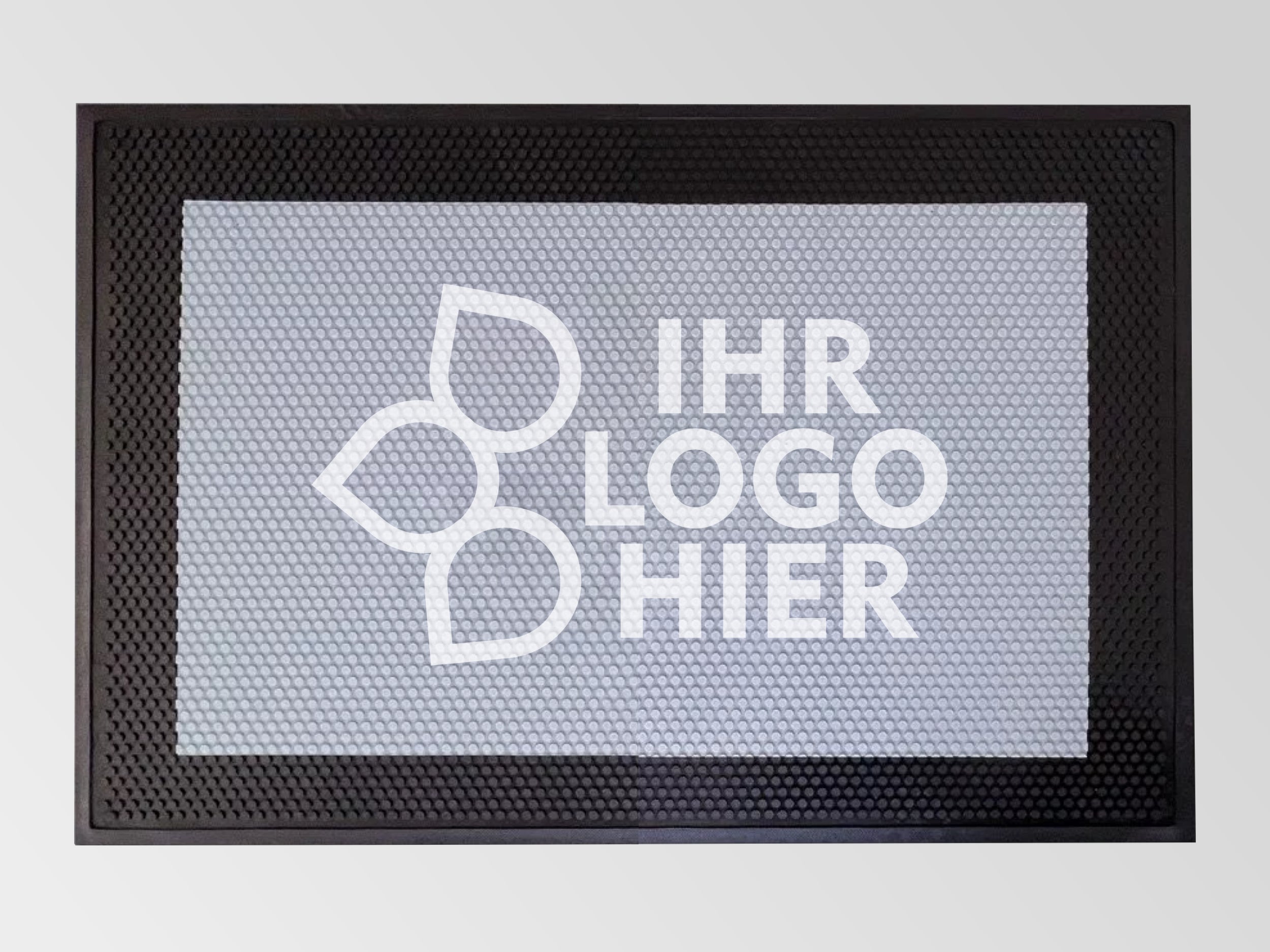 Der Fußabtreter Safe aus Gummi, der auf einem Betonboden liegt, hat eine strukturierte Oberfläche und eine Bedruckung mit dem Logo einer Tischlerei