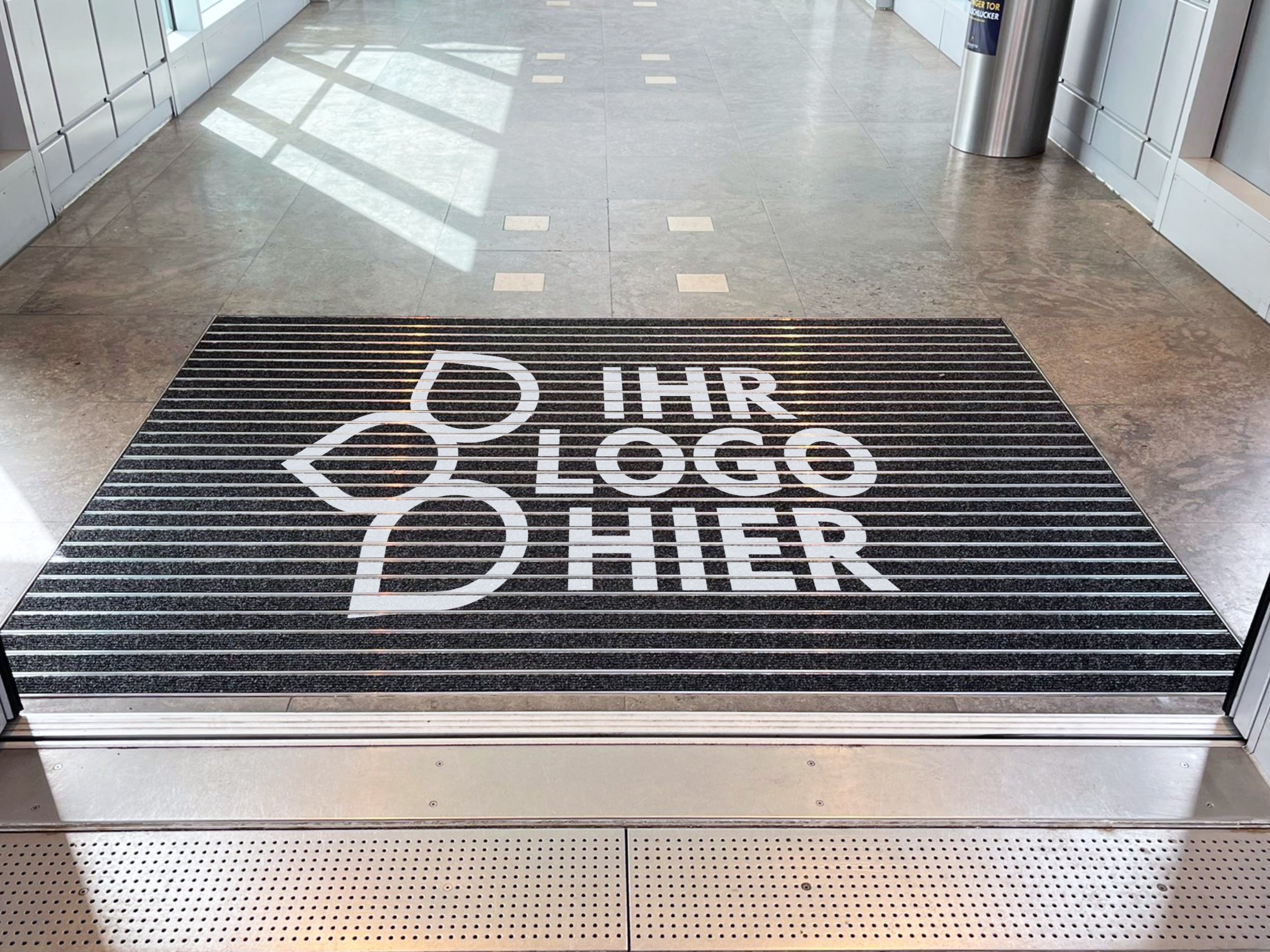 Aluprofilmatte im Boden eines Eingangsbereichs eingelassen mit Aufschrift – Ihr Logo hier