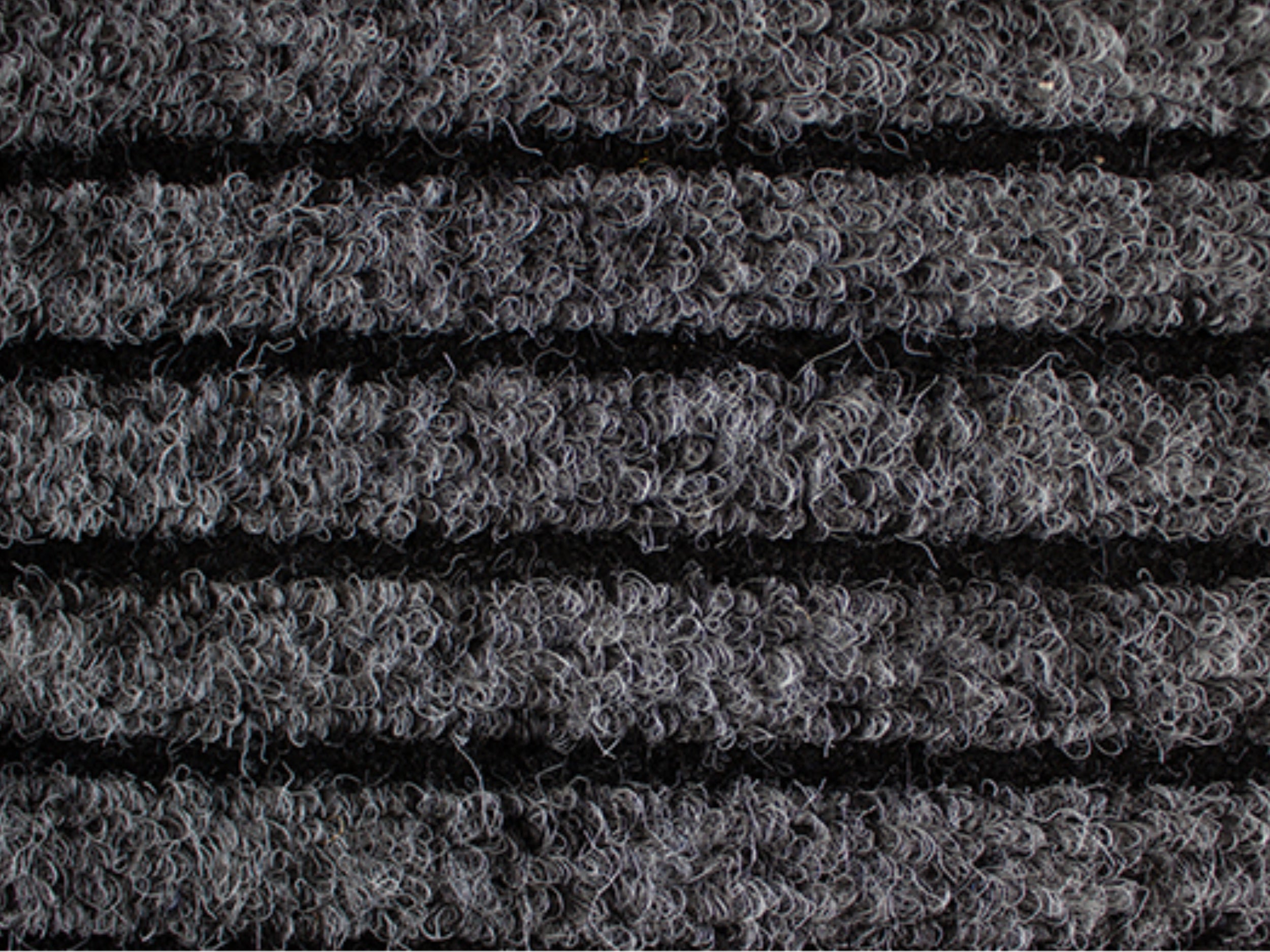Nahaufnahme der Textur einer Fußmatte aus Rauhaarrips in Anthrazit