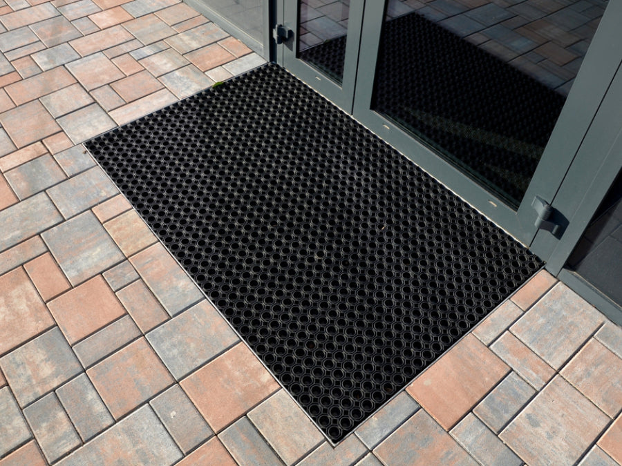 Eingelassene Ringgummimatte vor schwarzer Tür