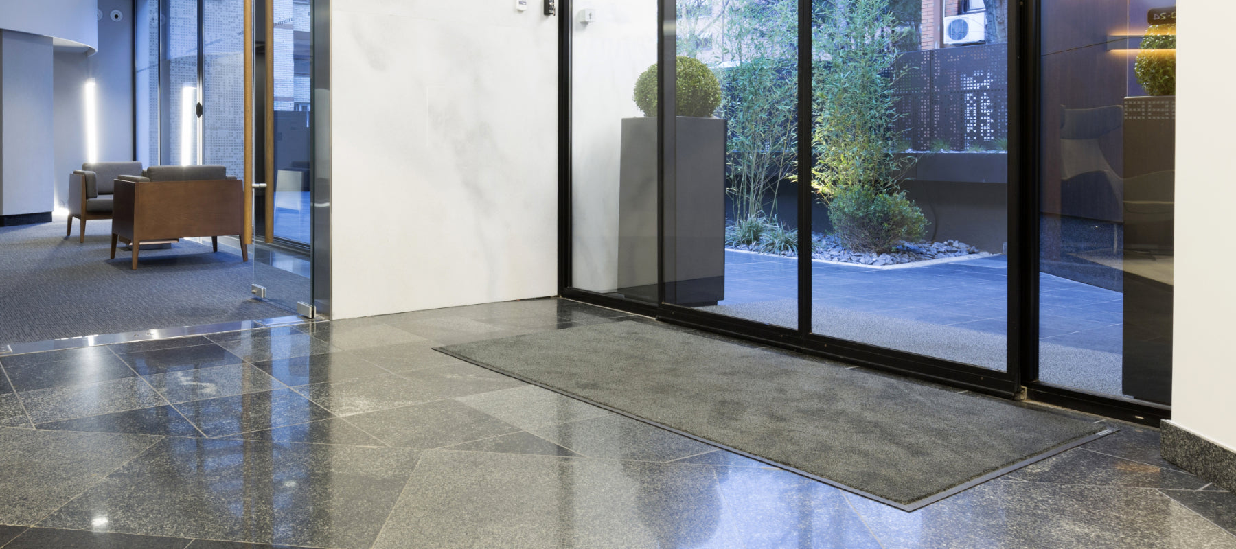 Schmutzfangmatte vor einer Schiebetür im Eingangsbereiches in einem Hotel