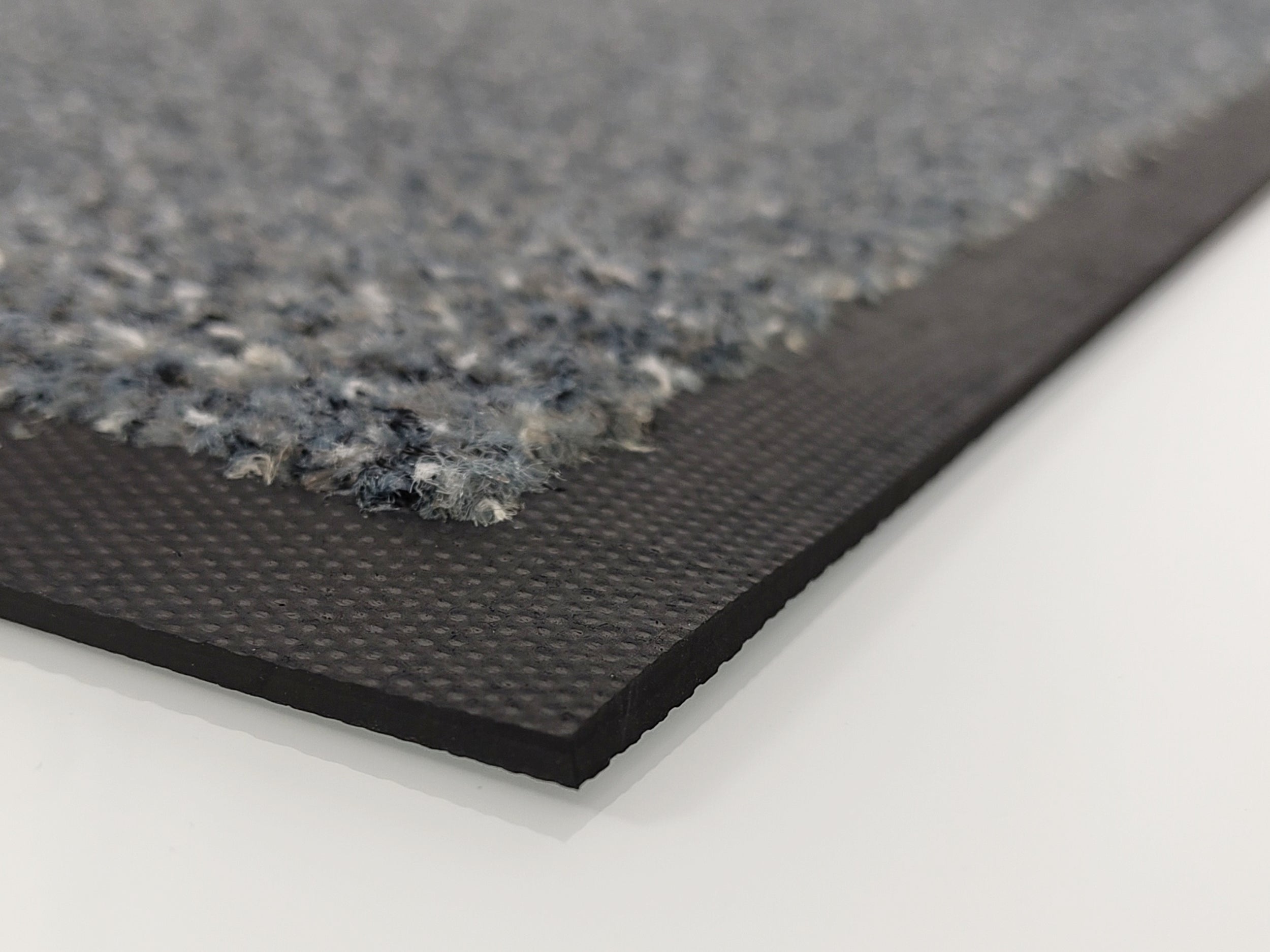 Ecke einer grauen Schmutzfangmatte mit Kratzfasern und Rand