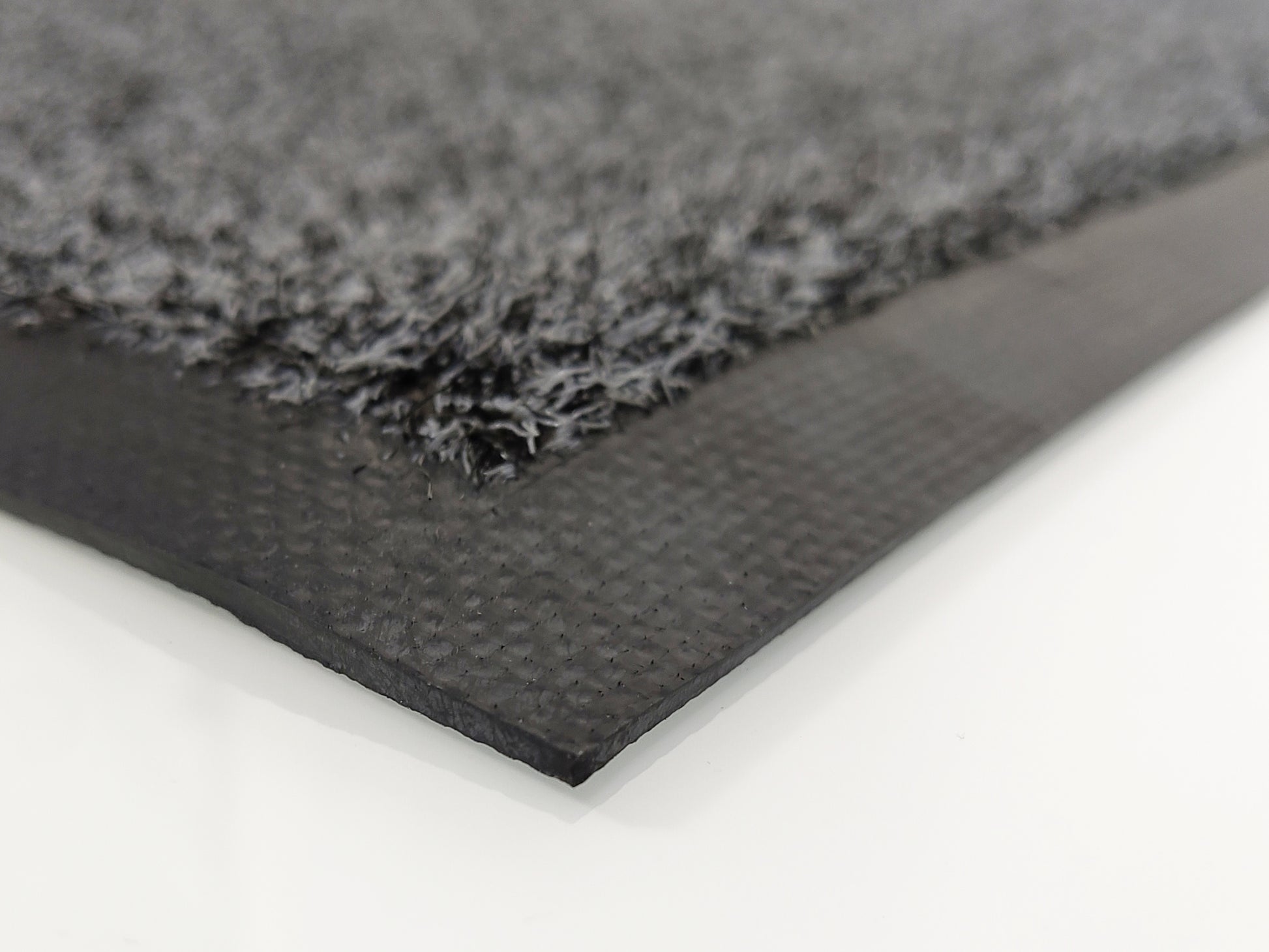 Nahaufnahme des schwarzen Nytril-Gummi-Randes einer grauen Schmutzfangmatte