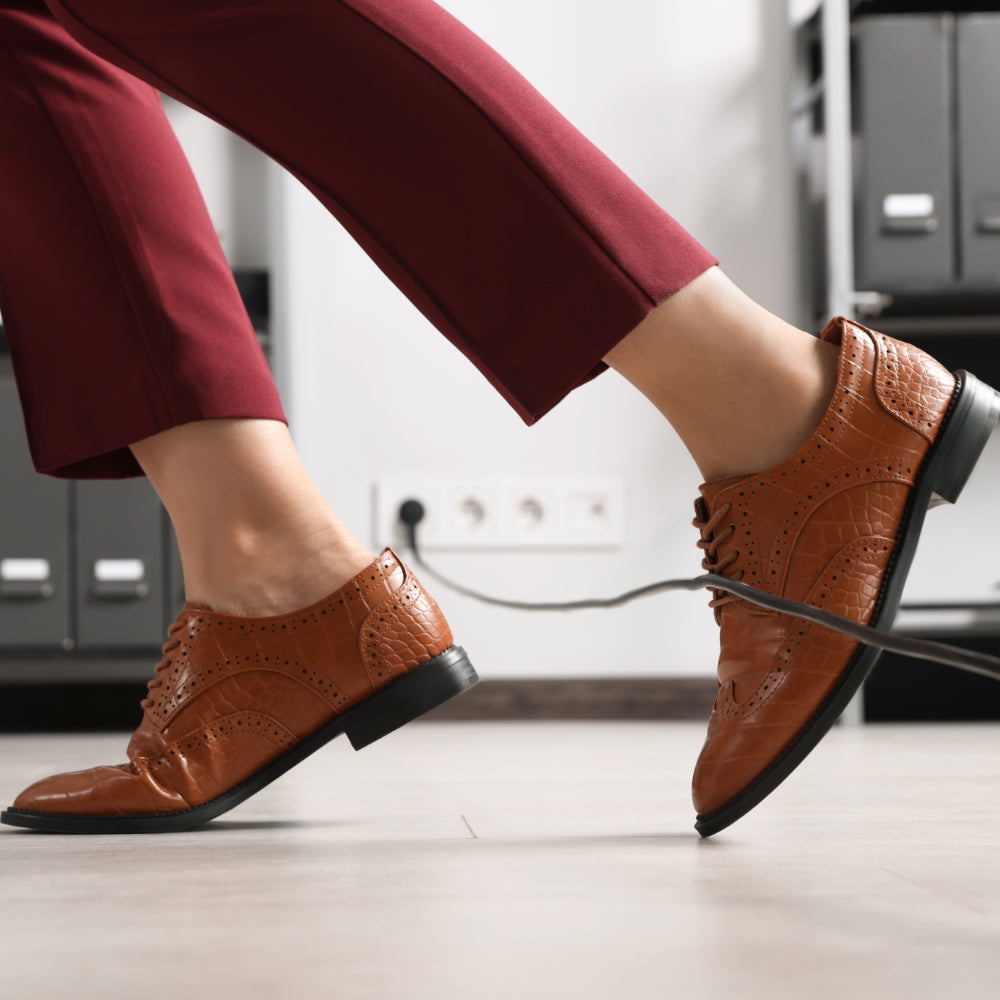 Bild von Füßen die über ein Kabel stolperln