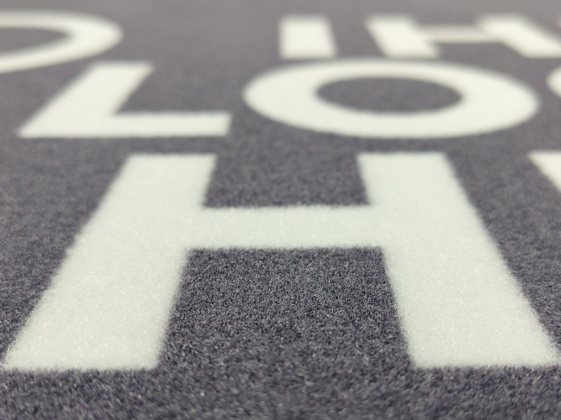 Nahaufnahme einer grauen Werbematte mit weißer Schrift