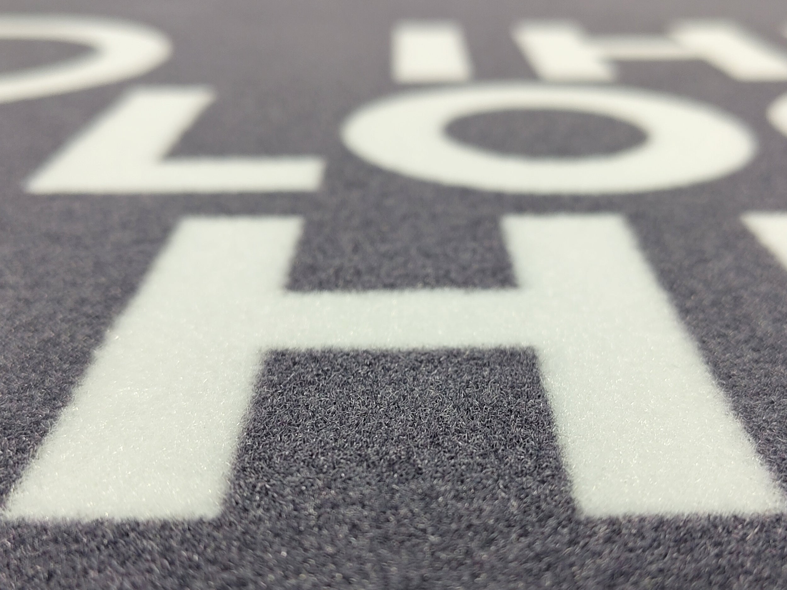 Nahaufnahme einer grauen Werbematte mit weißer Schrift