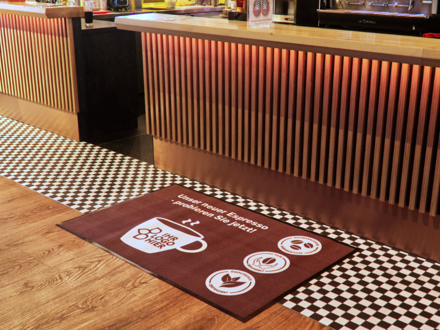 Werbematte mit Kaffee Logo vor Theke