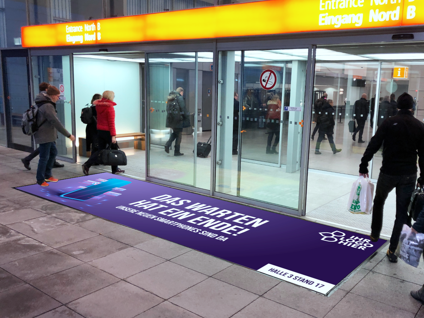 Werbematte mit Handymotiv, Informationen und Logo vor dem Eingang einer Messe