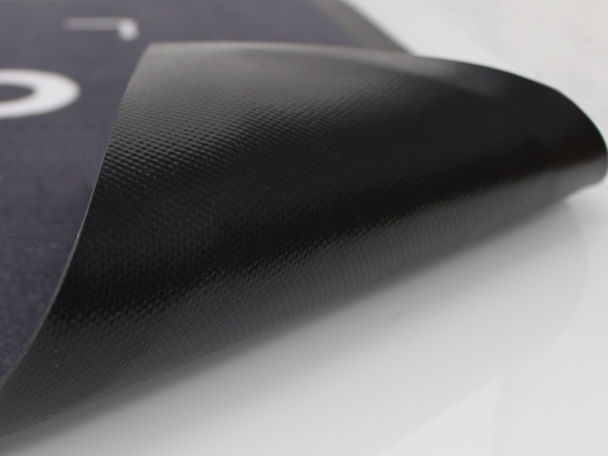 Umgeklappter PVC Rücken einer grauen Werbematte mit weißer Schrift