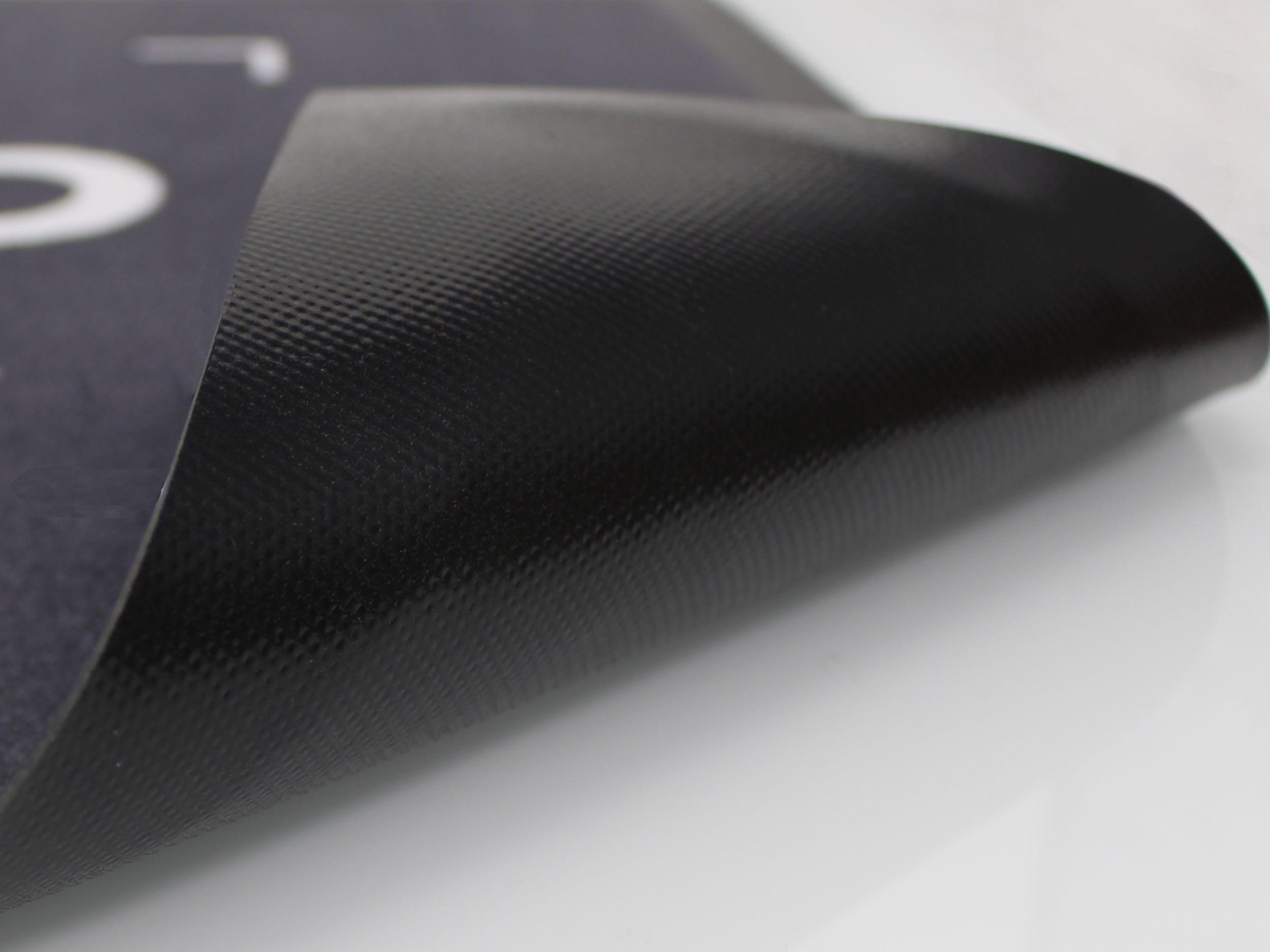 Umgeklappter PVC Rücken einer grauen Werbematte mit weißer Schrift