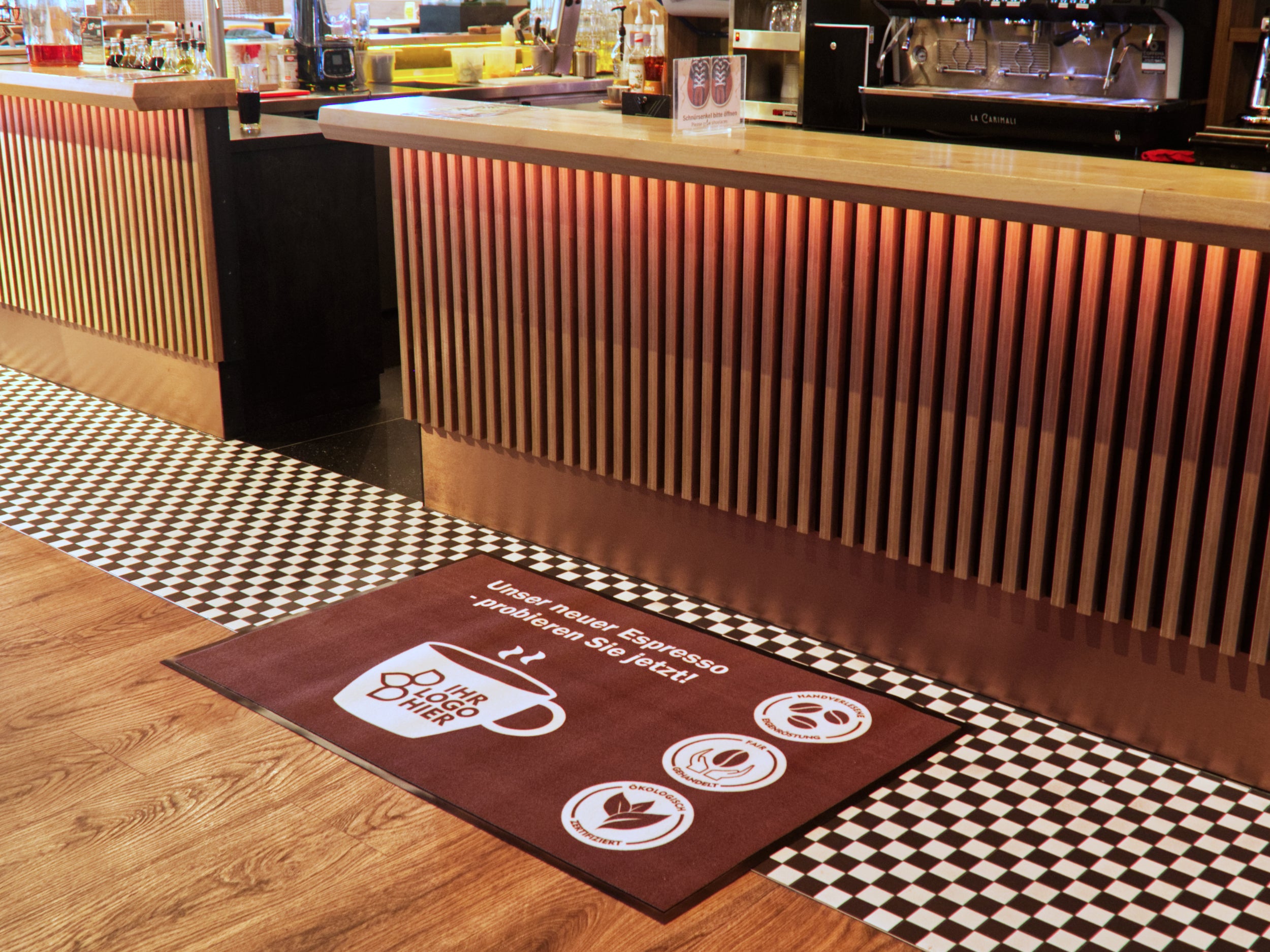 Werbematte liegt im Cafe vor der Theke mit Text und Logo zur neuen Espresso-Sorte