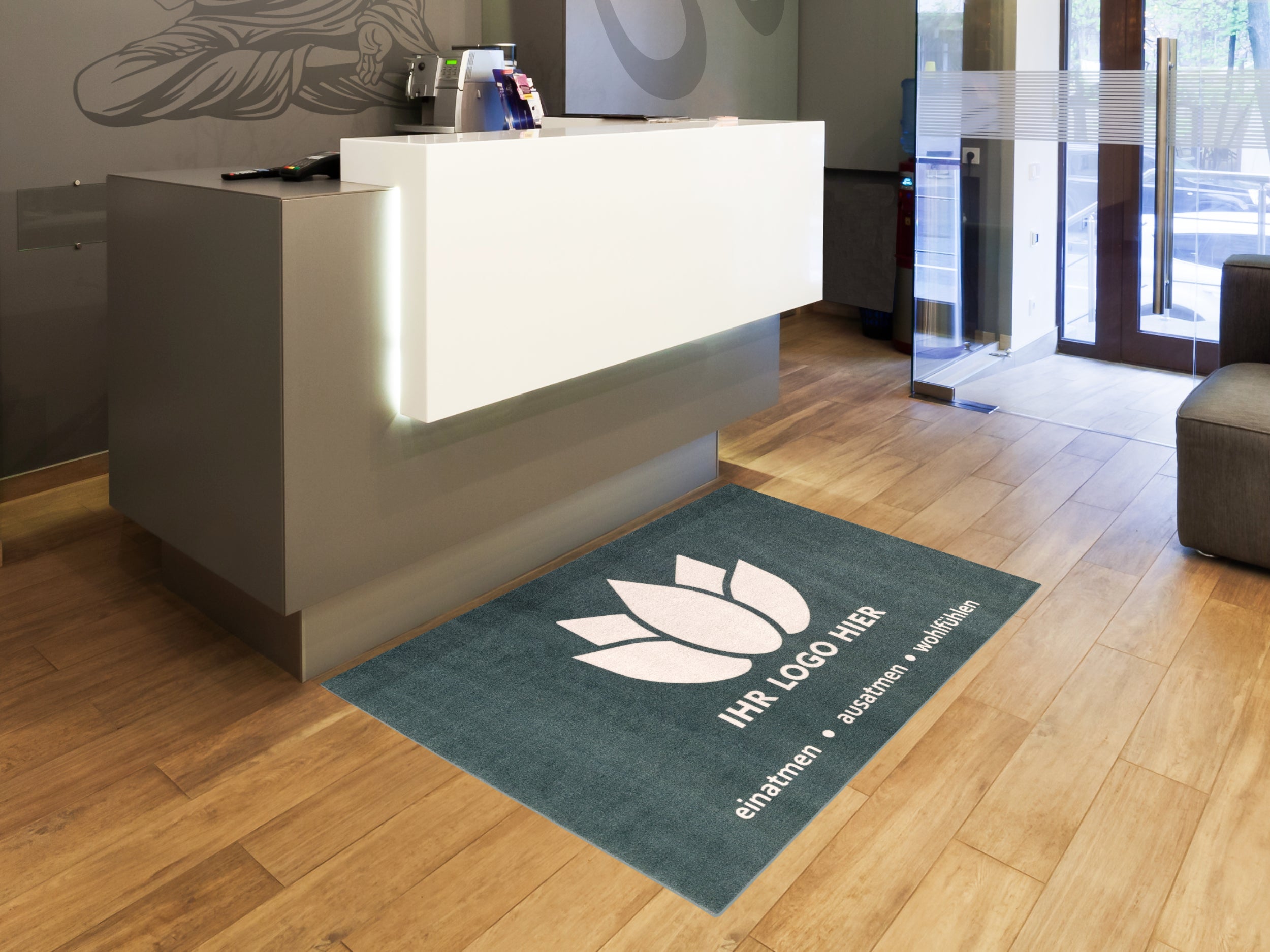 Petrolfarbende Werbematte mit Blumen-Logo mit Schrift im Eingangsbereich eines Studios