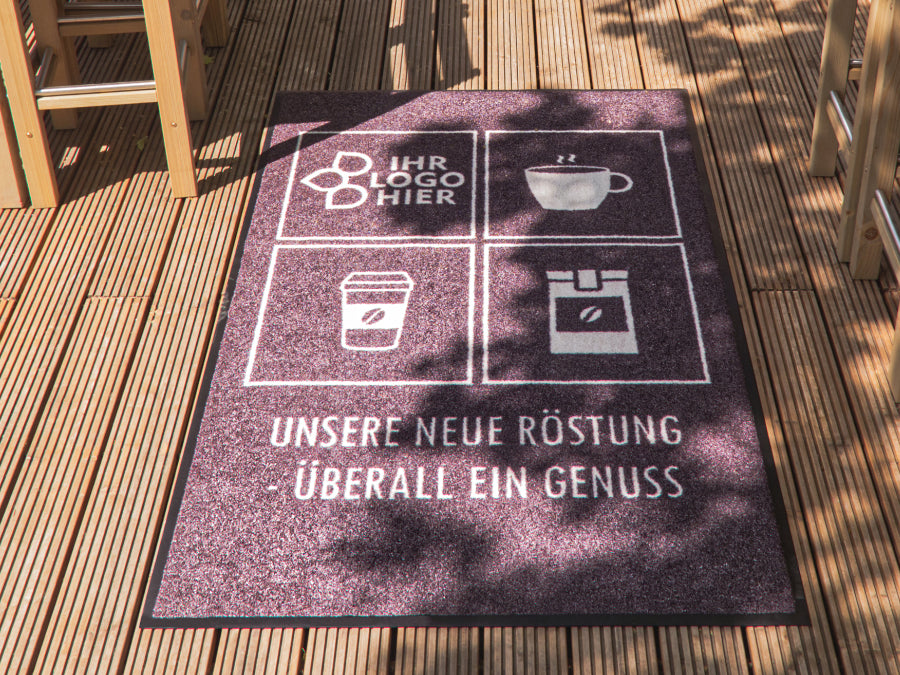 Wetterfeste Outdoormatte mit Cafe Logos Aufdruck im Außenbereich